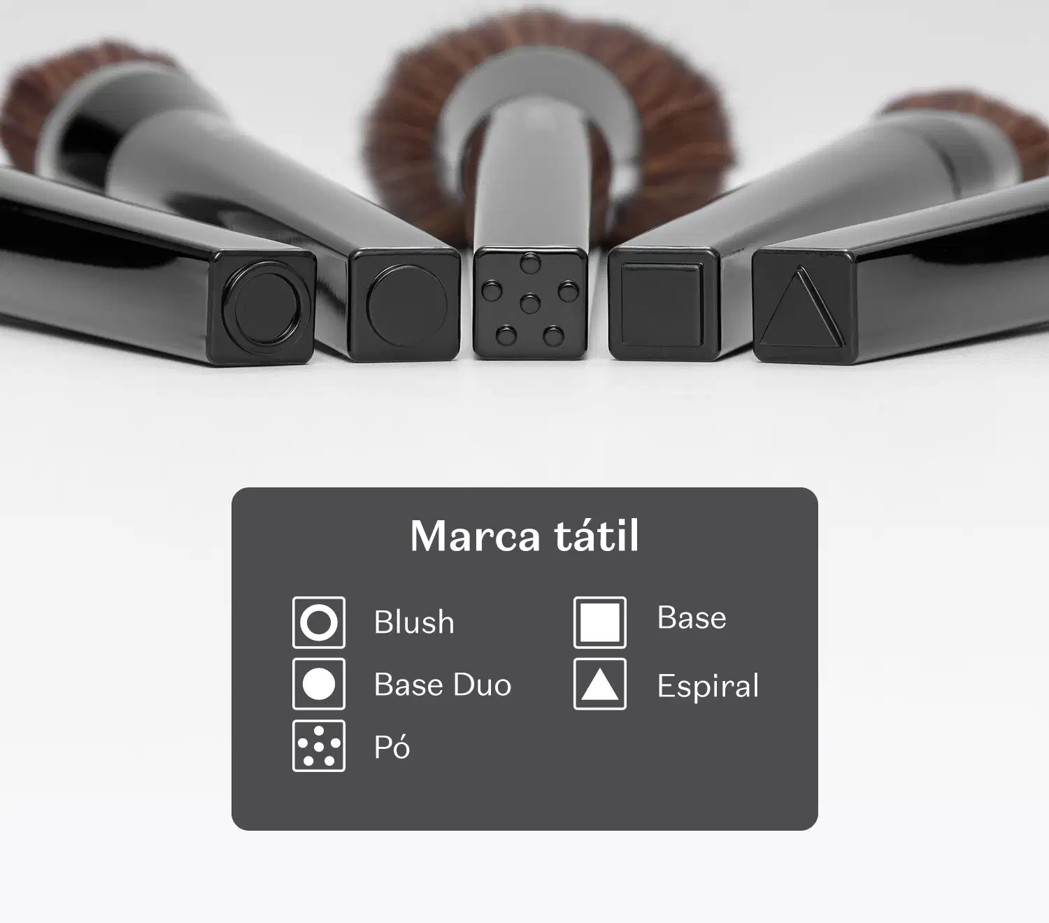A imagem mostra que os pincéis da linha possuem marca tátil na base, indicando sua finalidade. Círculo vasado blush, circulo cheio base duo, pontinhos pó, quadrado base e triângulo espiral.
