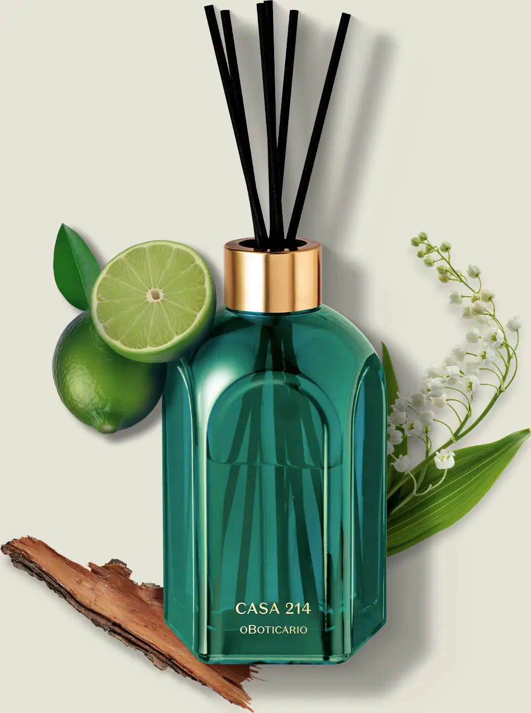 Difusor de ambientes em vidro verde com varetas e letras douradas da marca Casa 214 Brisa de Cedro cercado por folhas verdes, flor branca e pedaço de madeira em fundo bege claro.
