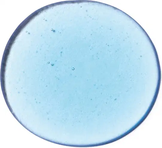 Imagem da textura azul clara, brilhante e com pequenas bolhas, em superfície lisa e transparente, mostrando a tonalidade do shampoo Next.
