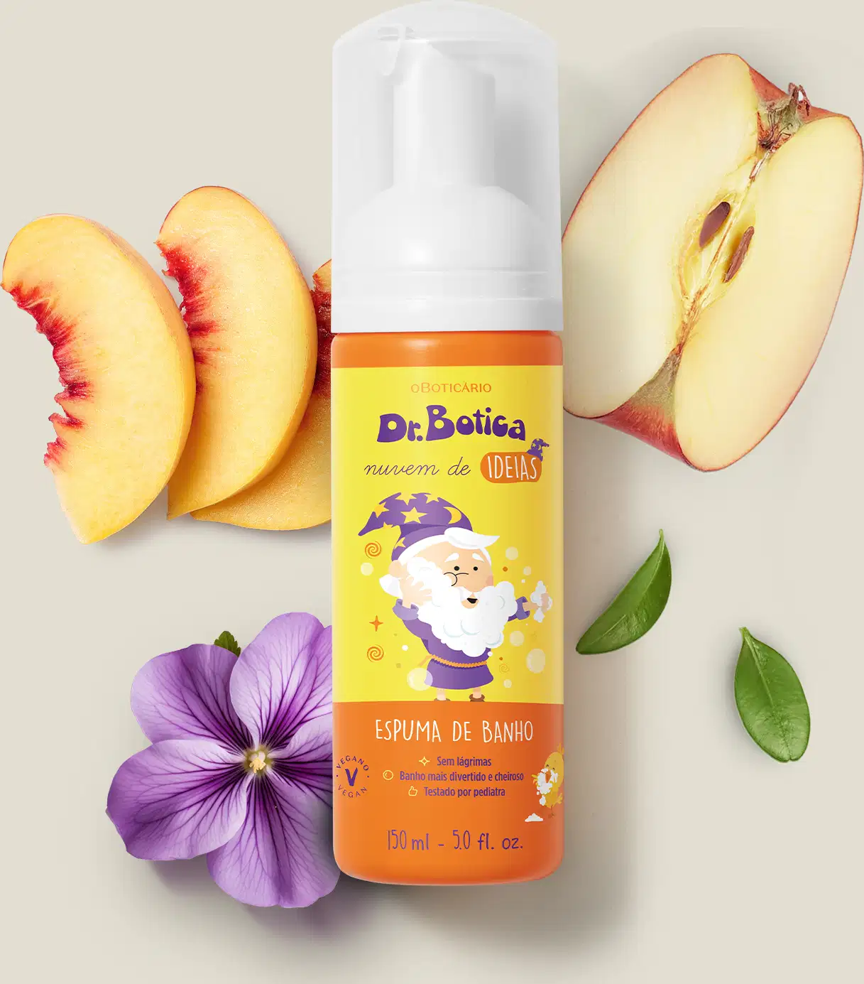 Espuma de banho corporal Nuvem de Ideias Dr. Botica em frasco com tampa branca e rótulo amarelo e laranja com ilustração do personagem da marca sobre superfície clara, com fatias de pêssego, maçã e flor roxa ao redor, em cenário minimalista e natural.