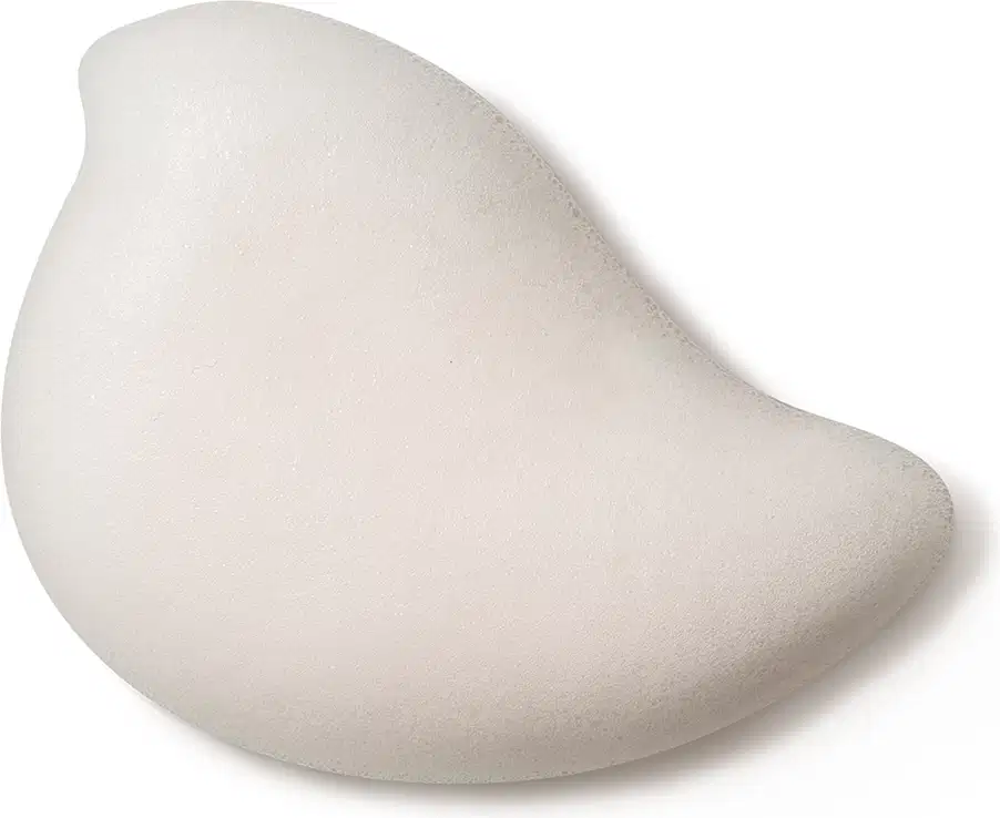 Textura branca, macia e cremosa da espuma de banho corporal Nuvem de Ideias Dr. Botica em superfície lisa e brilhante, posicionado sobre fundo branco.