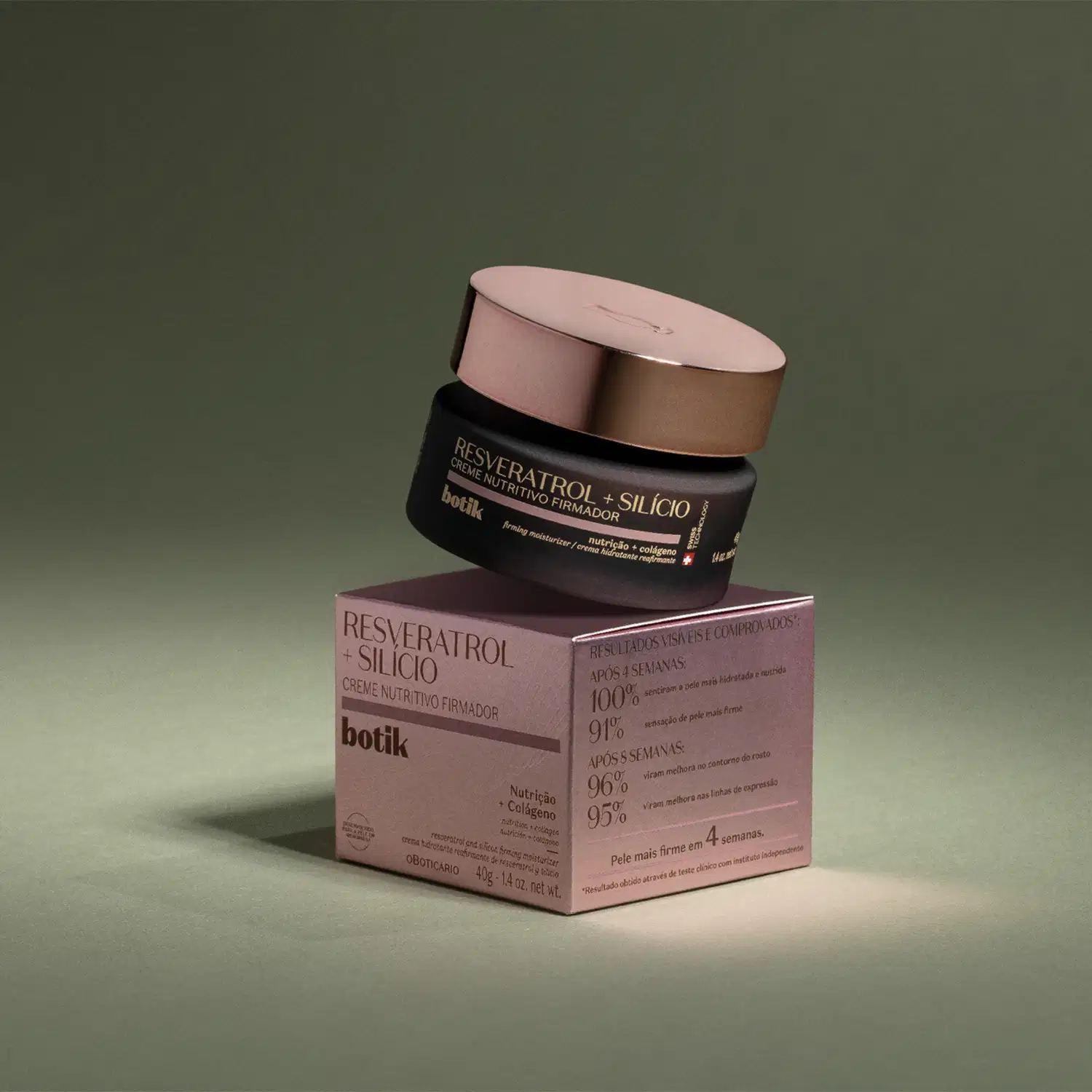 Pote marrom com tampa dourada de creme nutritivo firmador Botik Resveratrol E Silício em cima de uma caixa bege com letras marrons em fundo escuro com iluminação em cima dos itens.