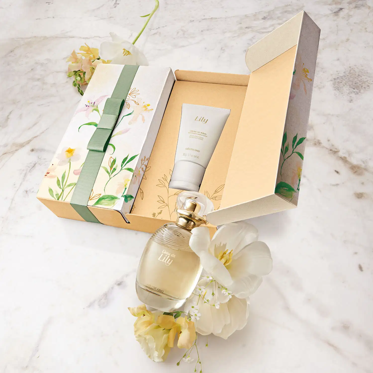 Caixa com ilustração de flores e folhagens coloridas, acompanhada de dois itens da marca L'eau de Lily: vidro oval com líquido bege e tampa dourada de desodorante colônia e frasco branco com tampa bege e letras douradas de creme de mãos.