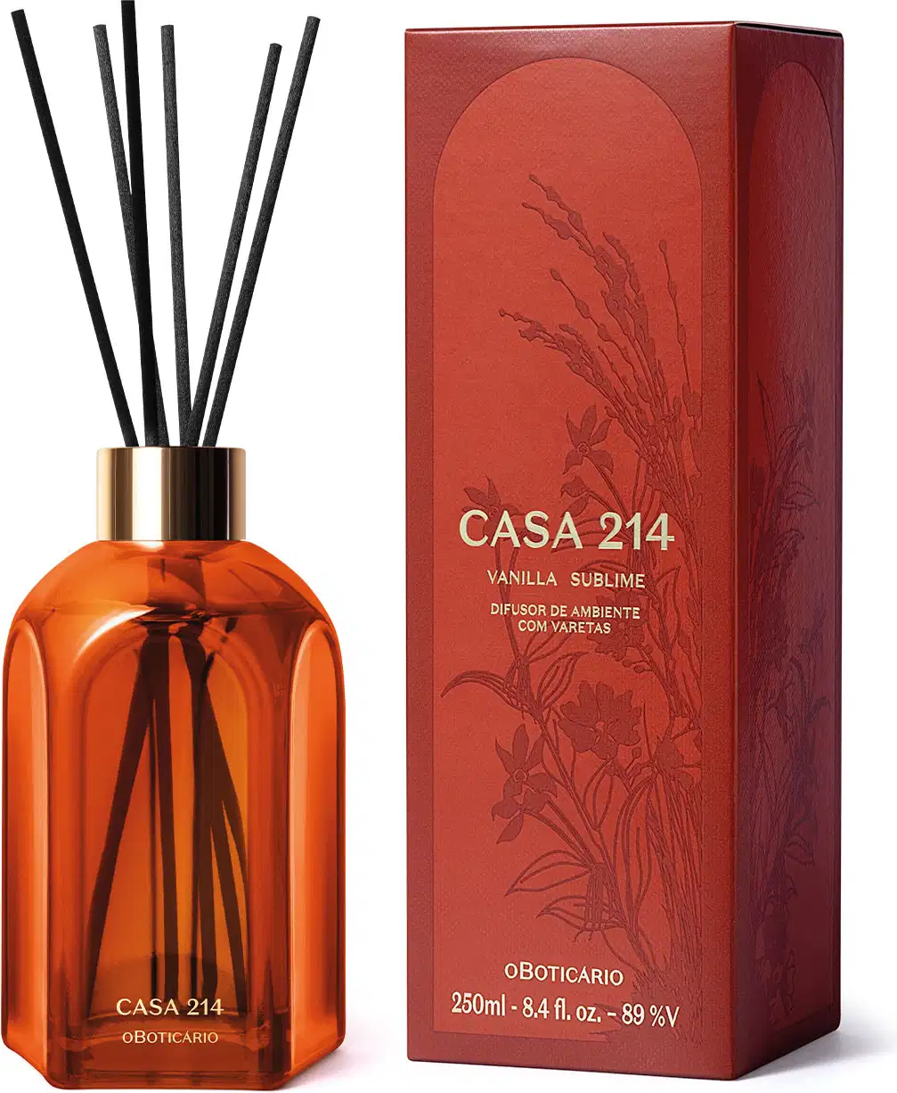 Difusor de ambientes em vidro laranja com varetas e letras douradas da marca Casa 214 Vanilla Sublime com a caixa laranja e dourada ao lado.
