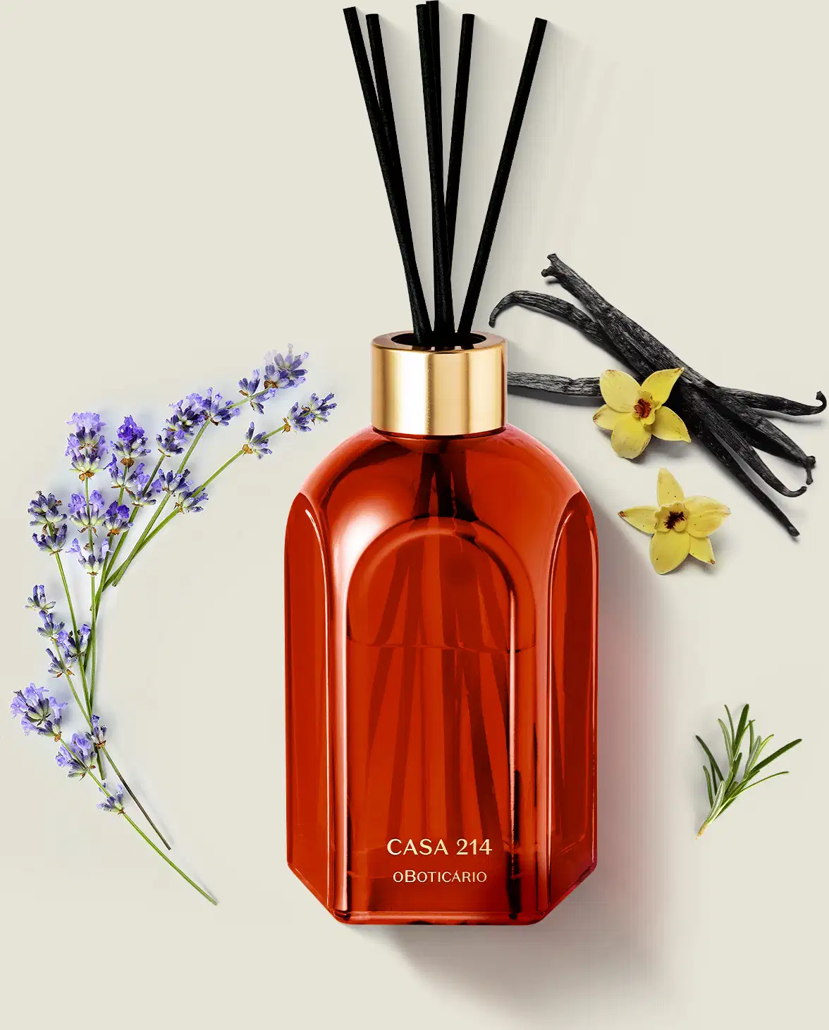 Difusor de ambientes em vidro laranja com varetas e letras douradas da marca Casa 214 Vanilla Sublime em ambiente com flores de lavanda, baunilha e ramos de madeira, sobre superfície clara.