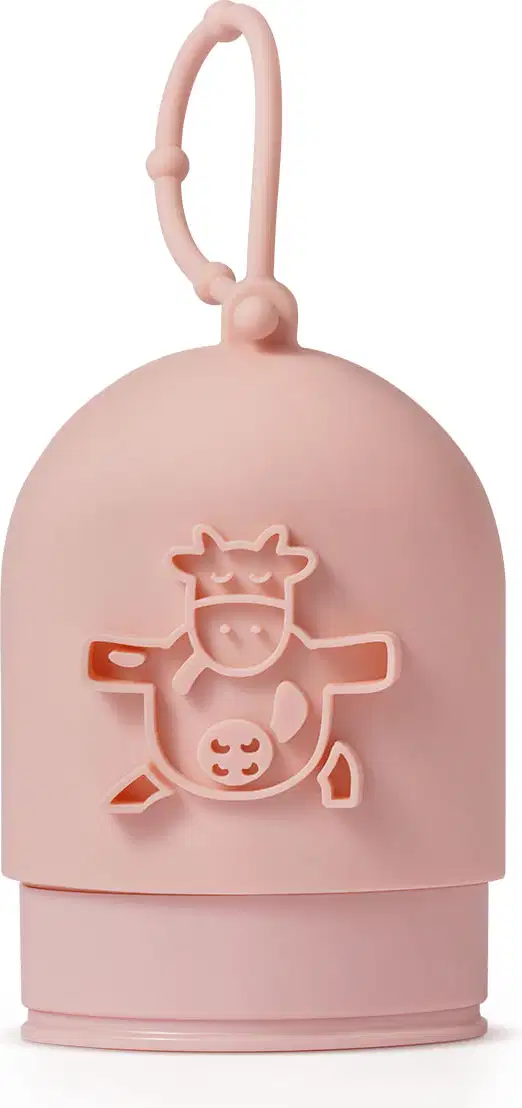 Capinha de silicone rosa para creme de mãos da marca Cuide-se Bem Deleite, com ilustração de uma vaquinha em relevo e alça para pendurar.