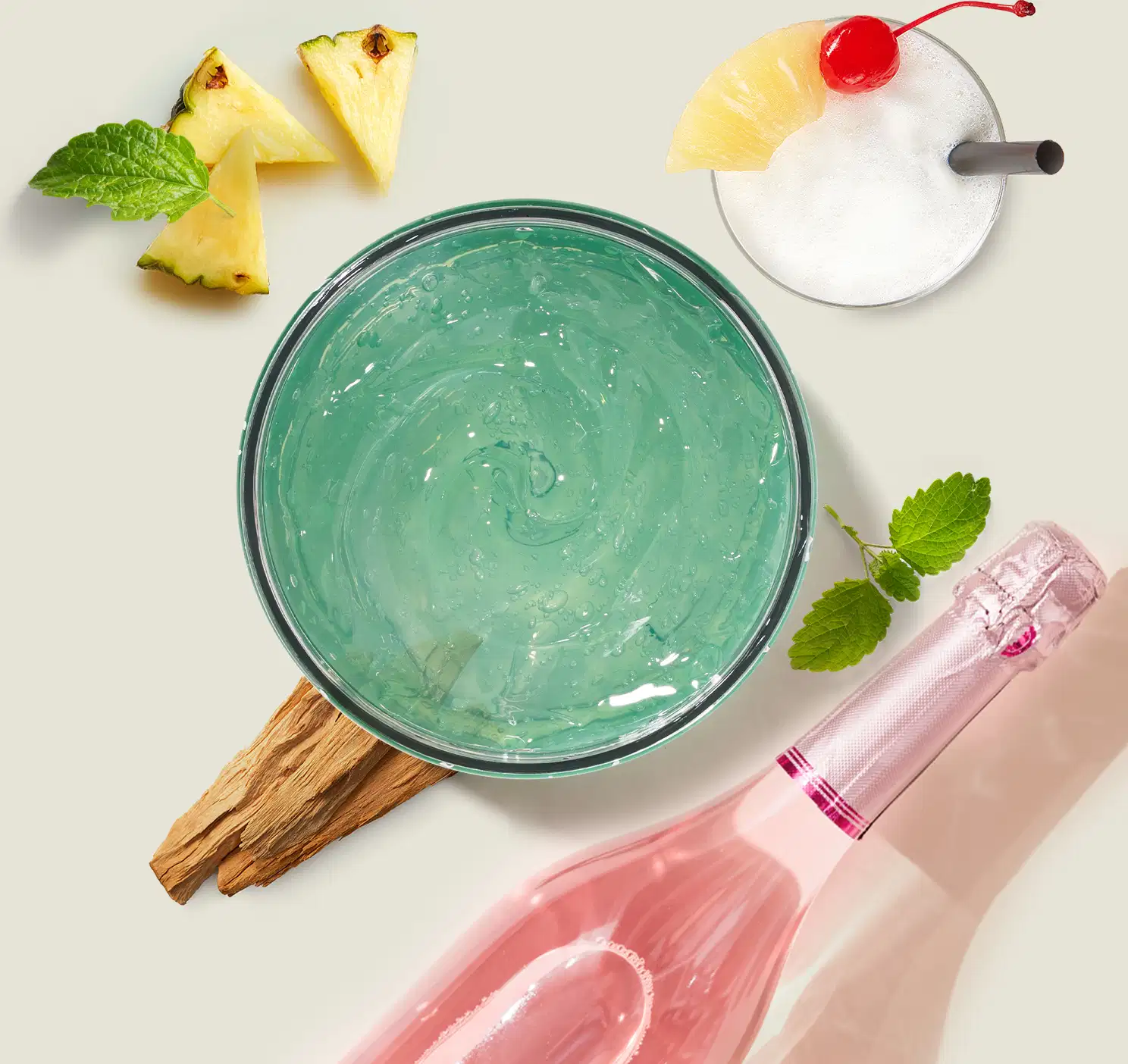 Pote de geleia desodorante refrescante corporal da marca Cuide-se Bem Bob Esponja e Amigos na cor verde, rodela de abacaxi e cereja no topo, acompanhado de pedaços de abacaxi, folhas de hortelã e uma garrafa com líquido rosa.