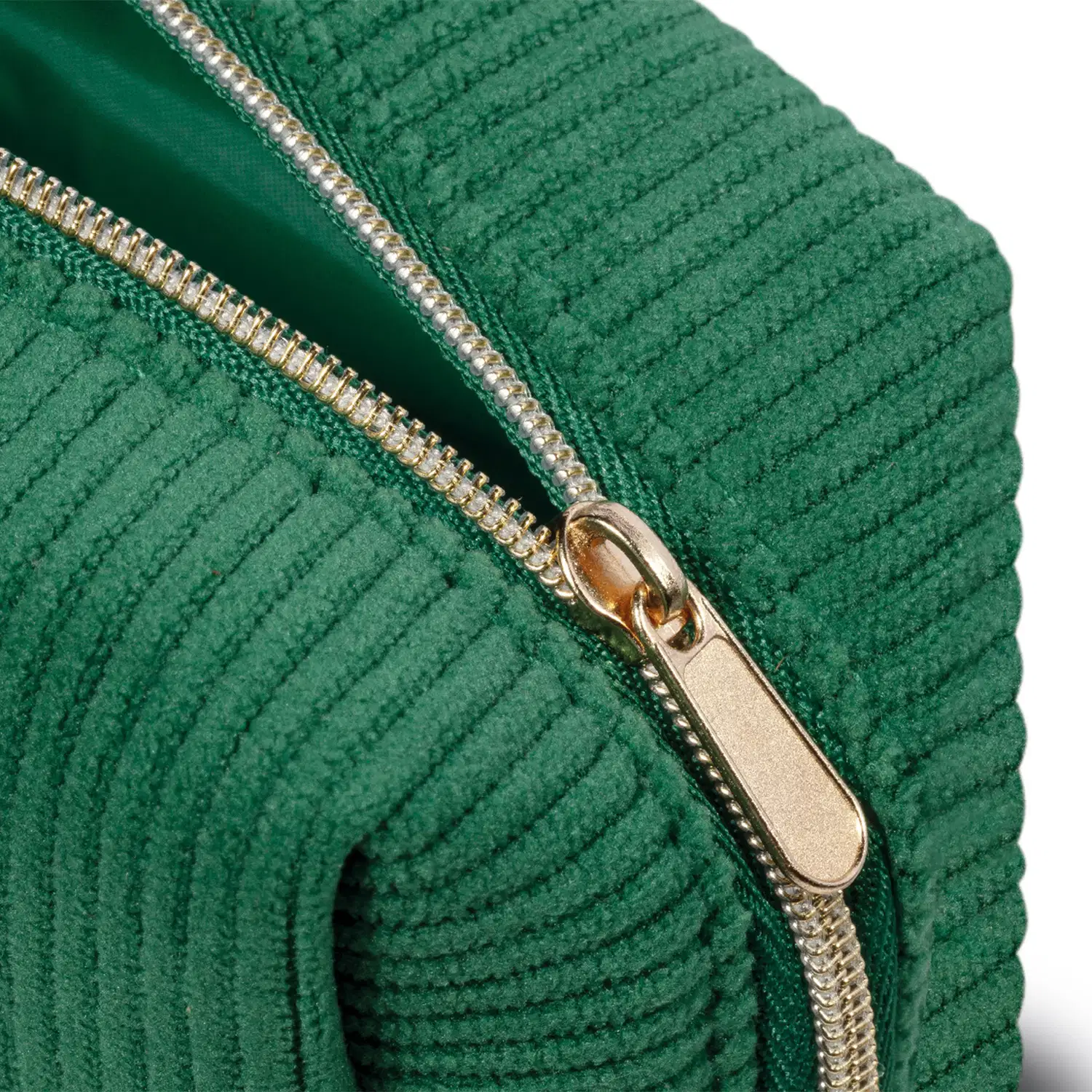 Close-up de necessaire de cor verde escuro visto lateralmente, com foco no zíper dourado aberto.