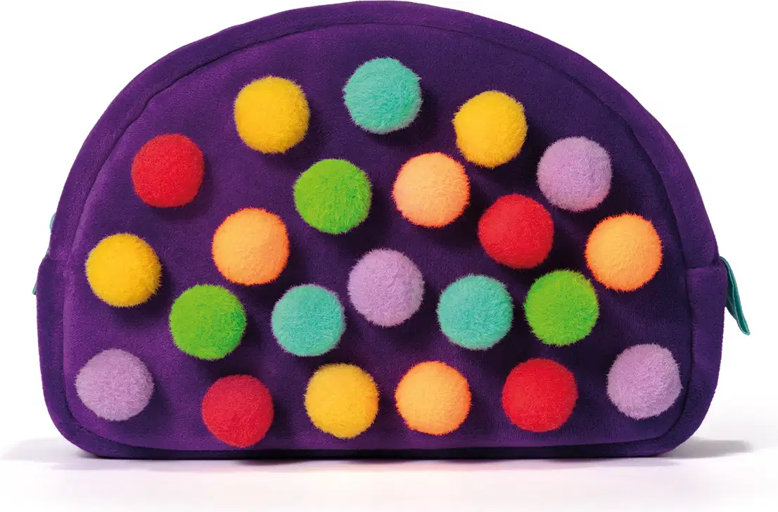 Necessaire em formato arredondado com zíper, confeccionado em tecido de cor roxa intensa. Sua superfície é totalmente revestida por pequenas bolinhas felpudas multicoloridas, incluindo tons de amarelo, laranja, vermelho, verde, turquesa e lilás.