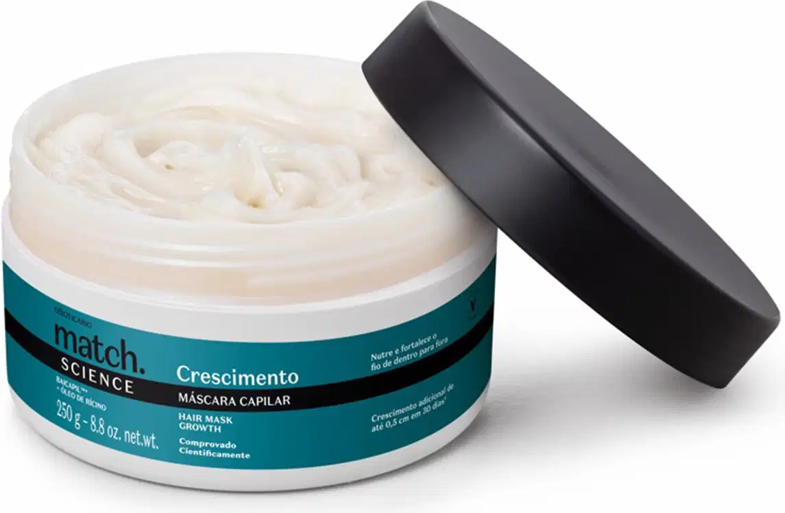 Pote branco aberto com creme branco dentro dele e tampa preta apoiada na embalagem. O produto possui rótulo na cor azul metalizado, preto e branco.