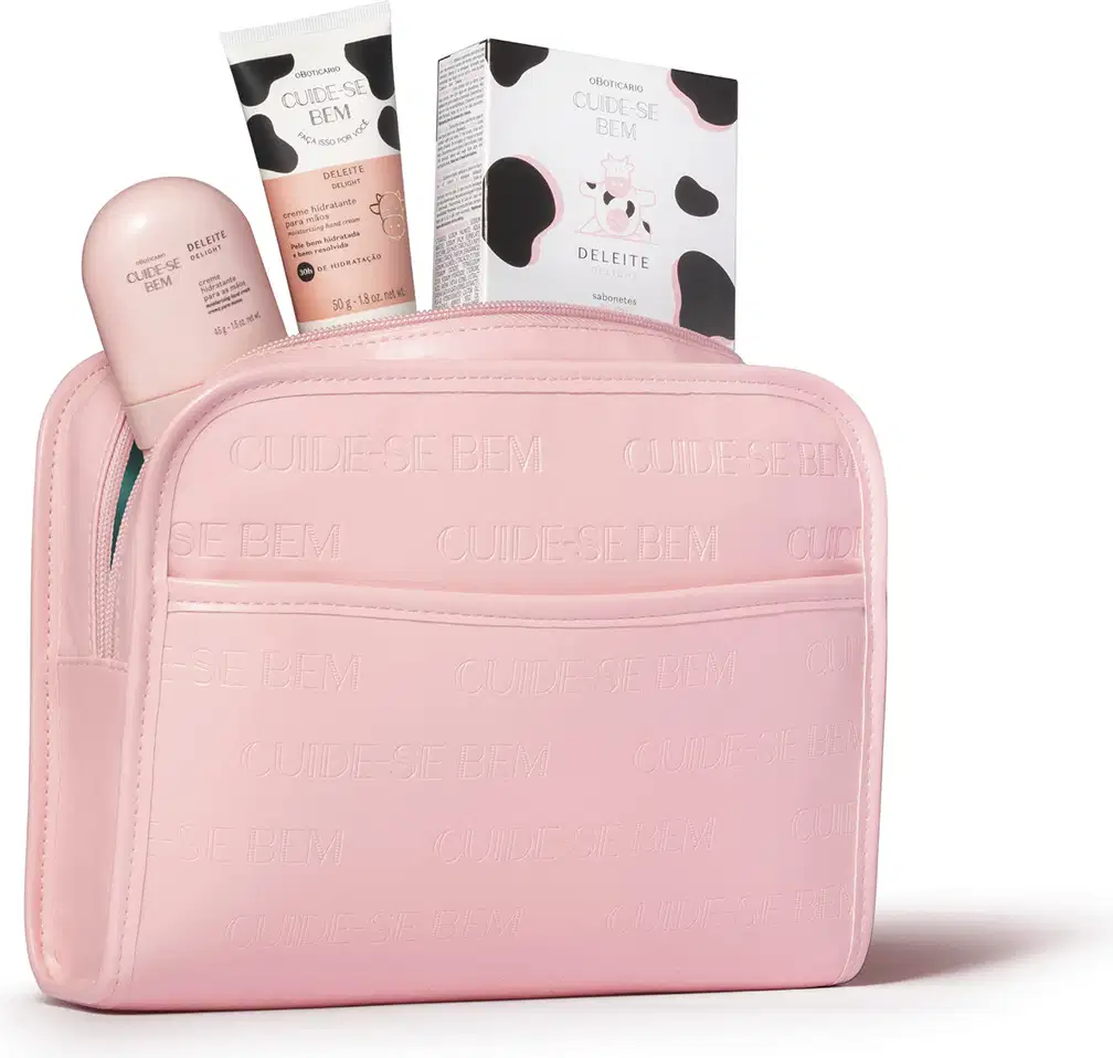 Necessaire em material sintético na cor rosa claro com zíper. Possui formato retangular com cantos arredondados. O estojo apresenta textura fosca e, de dentro dele, estão saindo vários produtos da marca Cuide-se Bem.