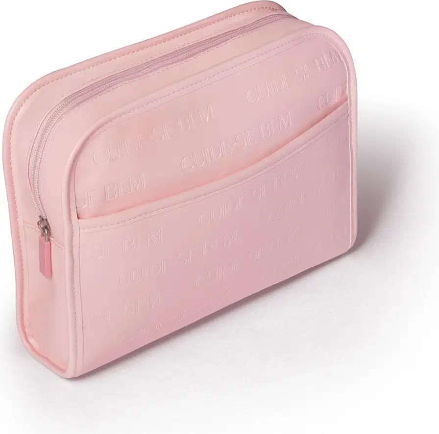 Necessaire em material sintético na cor rosa claro com zíper. Possui formato retangular com cantos arredondados. Ele  apresenta textura fosca e tem o nome da marca "Cuide-se bem" gravado em relevo na parte frontal.