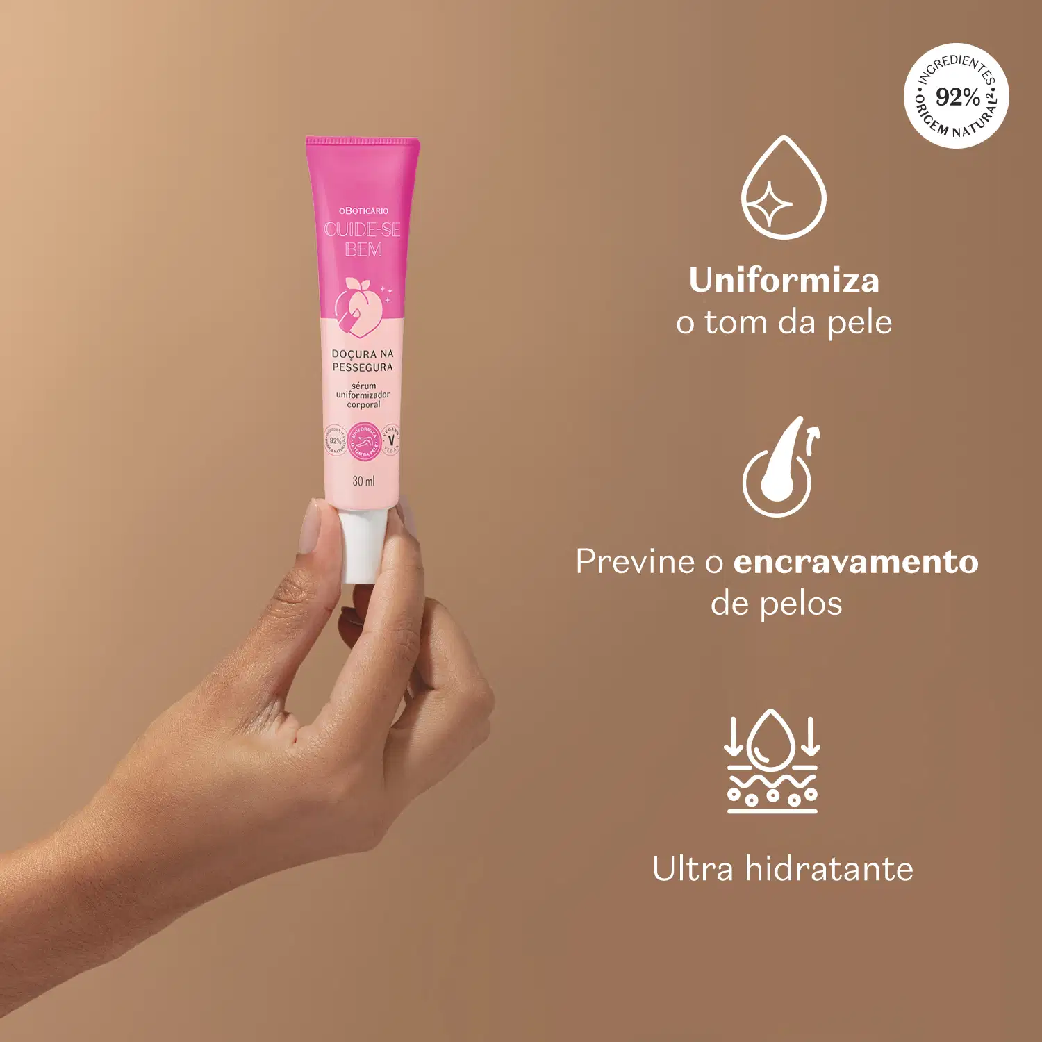 Mão feminina segurando tubo rosa de sérum uniformizador com texto branco sobre fundo bege que diz "Uniformiza o tom da pele, Premine o encravamento de pelos e Ultra hidratante".