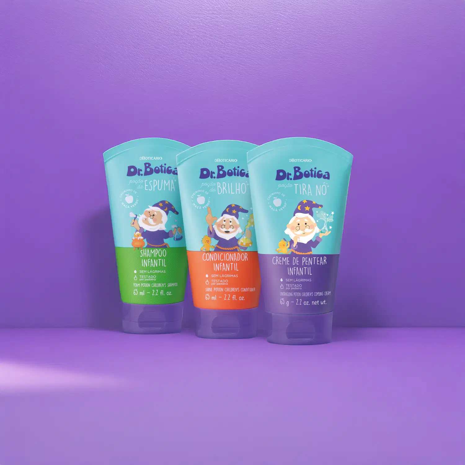 Três embalagens de produtos infantis da marca Dr. Botica em fundo roxo, incluindo shampoo, condicionador e creme de pentear, com ilustrações de personagem da marca.