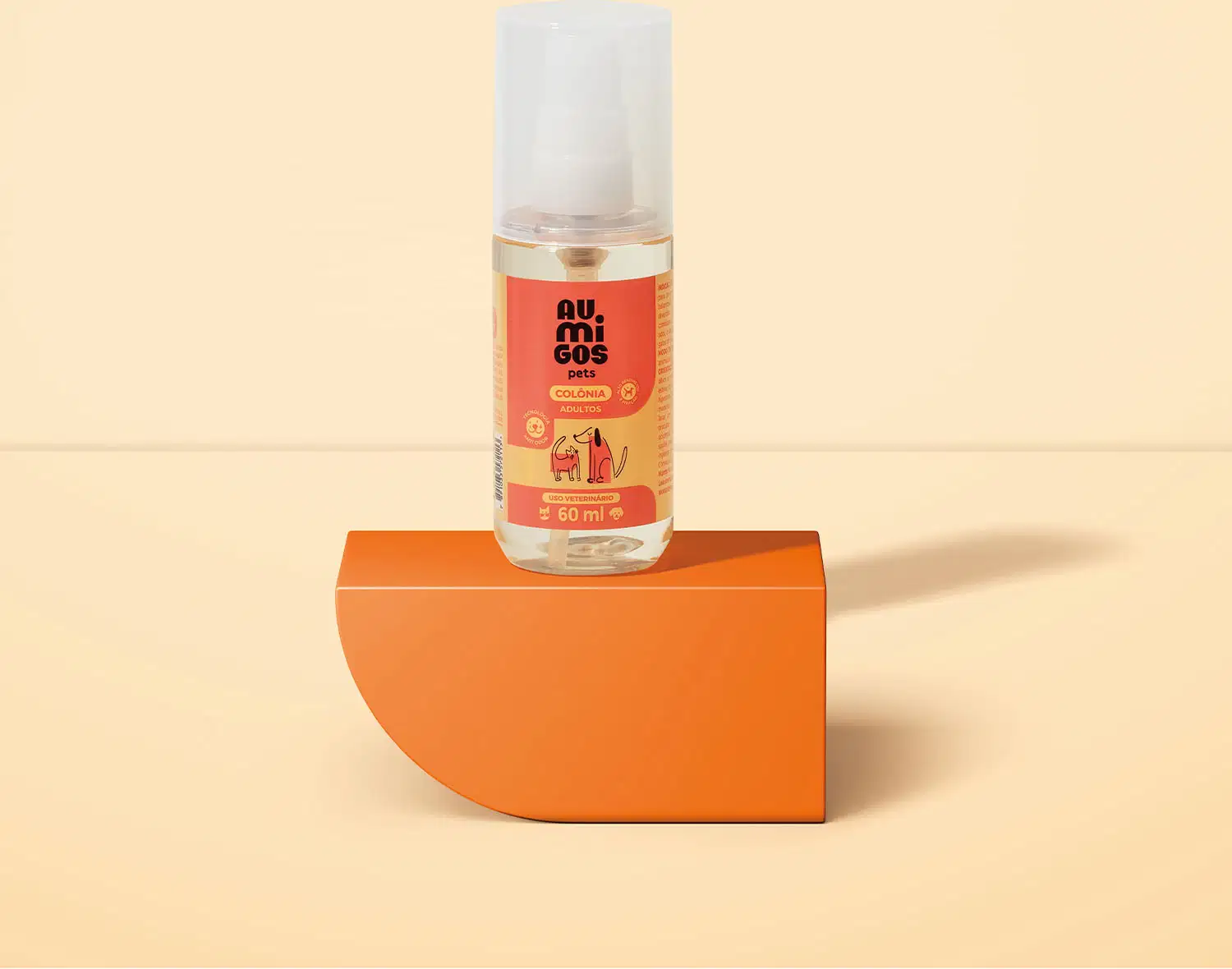 Frasco transparente com líquido claro, válvula spray branca, tampa transparente e rótulo laranja e rosa com ilustrações de um gato e de um cachorro contendo colônia adultos da marca Au.Migos Pets. O produto está em uma plataforma e fundo laranja.
