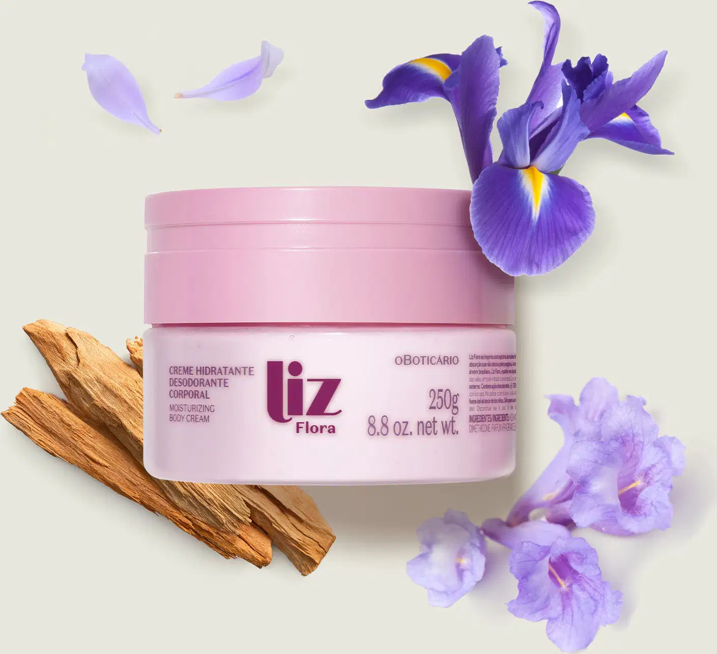 Pote rosa claro com tampa rosa e letras vinho contendo creme hidratante corporal Liz Flora com flores de íris roxas e galhos de madeira em fundo branco.