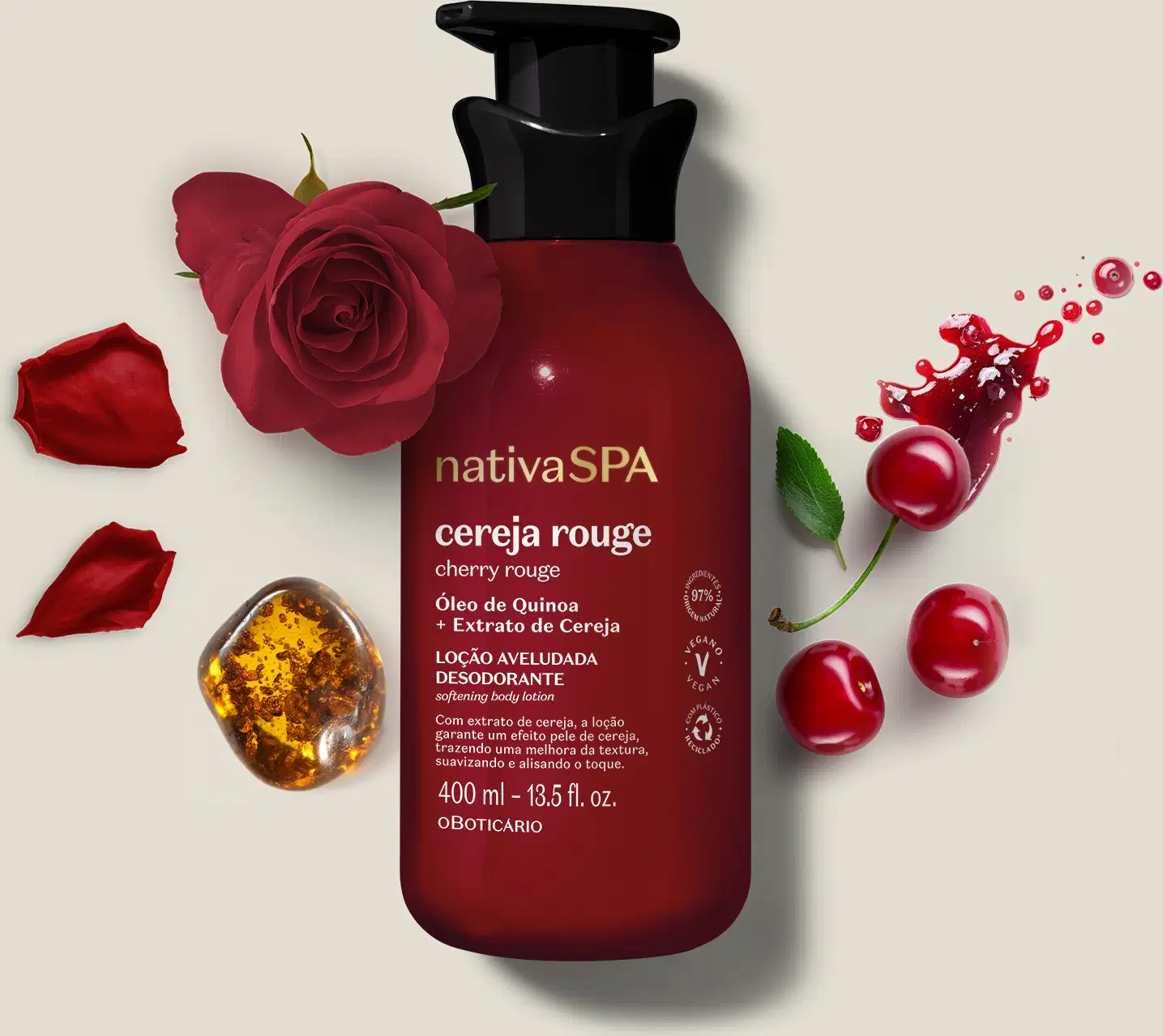 Embalagem vermelha escura de loção aveludada corporal Nativa SPA Cereja Rouge cercada por pétalas de rosa vermelha, cerejas e respingos de líquido vermelho sobre superfície clara.