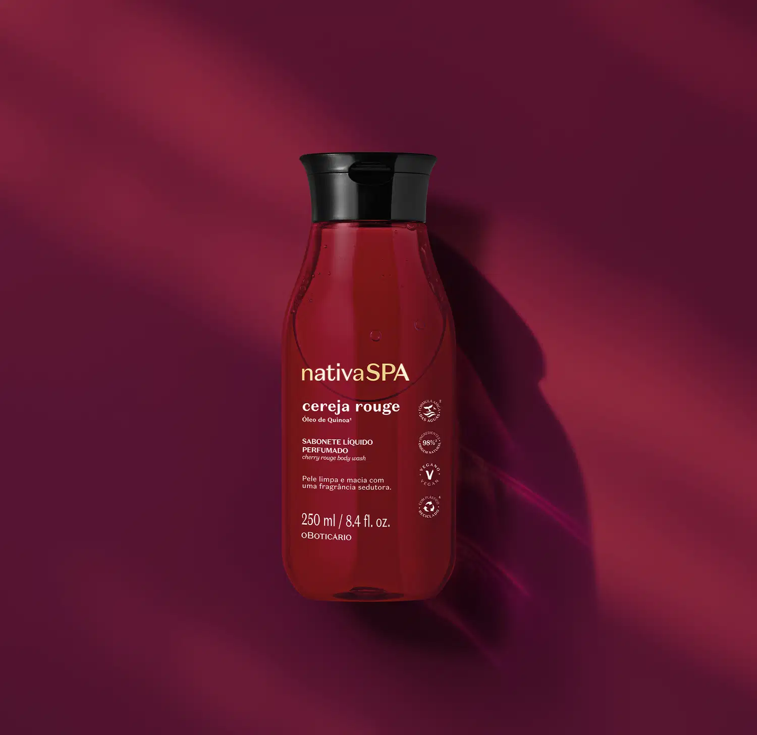 Frasco transparente com liquido vermelho escuro, tampa preta e rótulo em letras brancas e douradas contendo 250ml de sabonete líquido da arca Nativa SPA Cereja Rouge em fundo vermelho escuro.
