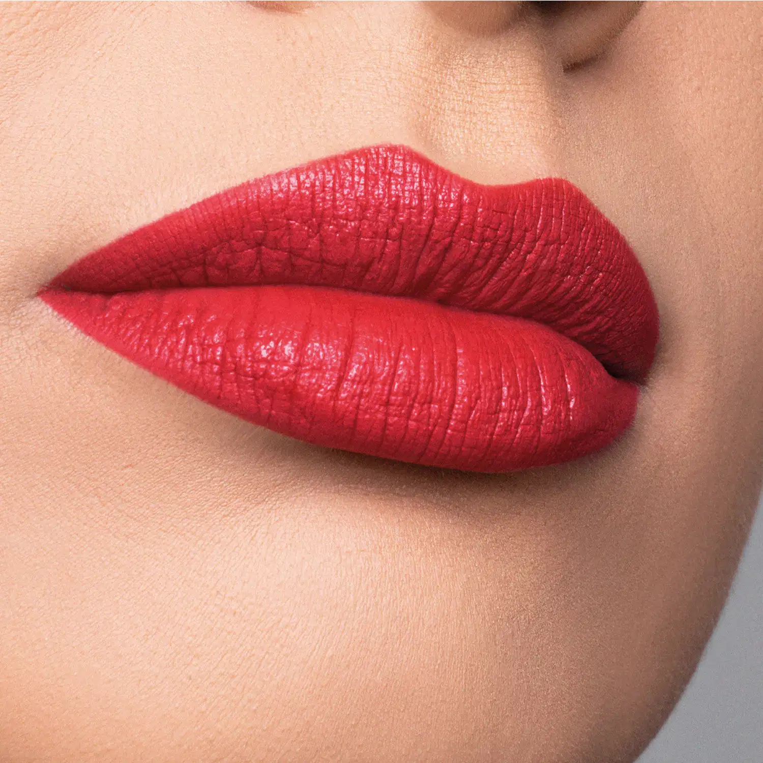 Close-up de um rosto feminino evidenciando os lábios com batom cermelho Red Cherry cremoso Make B. Cereja Rouge.