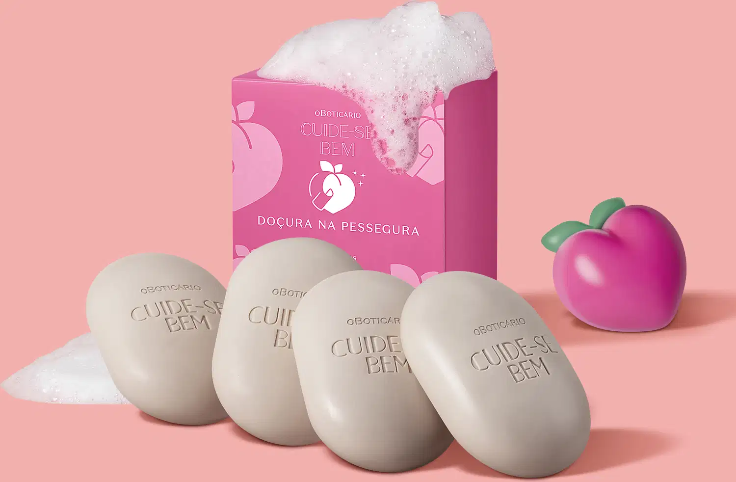A imagem mostra 4 barras de sabonete Cuide-se Bem Doçura na Pessegura, com fundo rosa, caixa do produto na cor pink com um pouco de espuma em cima e pêssego de plástico também na cor pink.