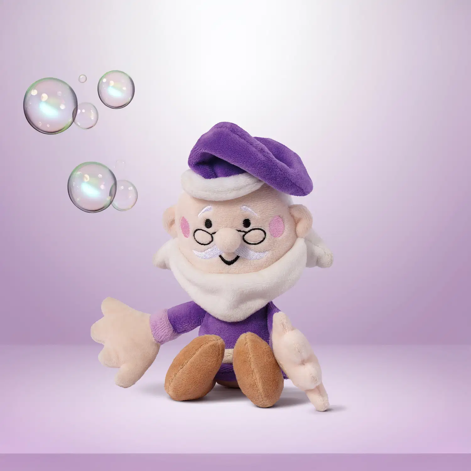 boneco de tecido macio, personagem da marca Dr. Botica, um senhor de barba branca, óculos pretos, gorro e roupas roxas em um fundo e superfície em tons de roxo e branco com bolhas ao redor.