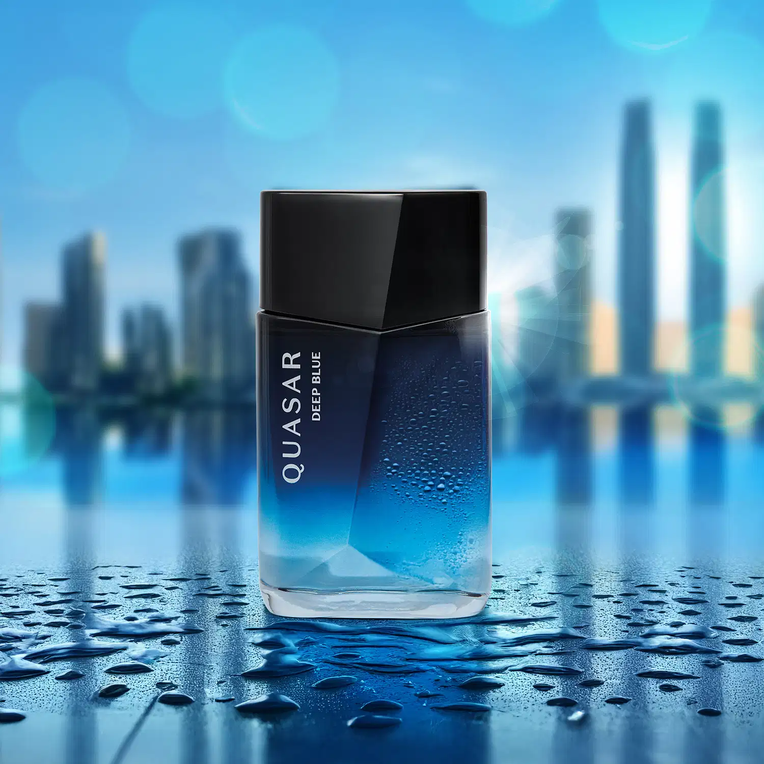 Frasco de desodorante colônia da marca Quasar Deep Blue em primeiro plano, com gotas d'água, sobre superfície reflexiva e desfocada de arranha-céus em uma cidade ao fundo.