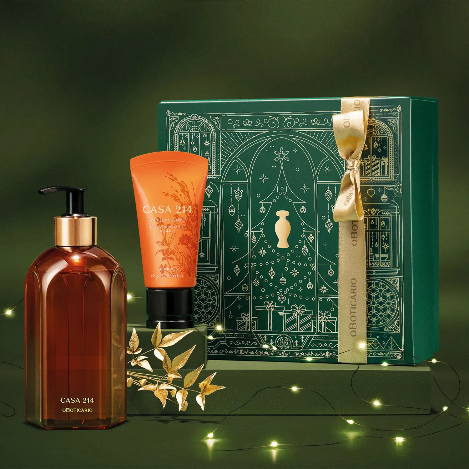 Caixa verde com detalhes dourados e dois itens Casa 214 Vanilla Sublime: bisnaga laranja com tampa preta de creme hidratante de mãos e um vidro laranja com bomba dosadora preta de sabonete líquido em fundo verde com luzes de natal e flor dourada.
