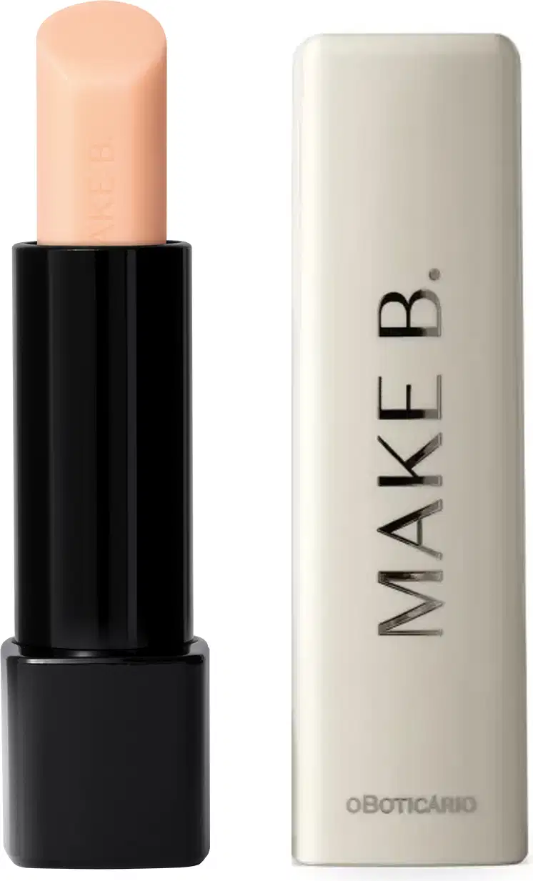 O produto exibido na imagem é um balm labial noturno da marca Make B. Lip Chronology Night Plump. A embalagem é composta por um tubo preto com uma tampa branca. O produto em si possui uma cor bege clara e suave.
