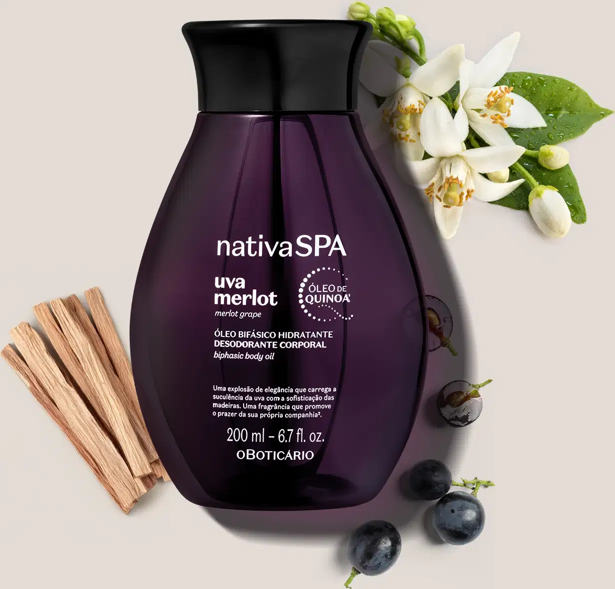 Frasco de óleo hidratante corporal da marca Nativa SPA Uva Merlot em embalagem roxa, com flores brancas e folhas verdes ao redor, sobre superfície clara com uvas e madeira ao redor.