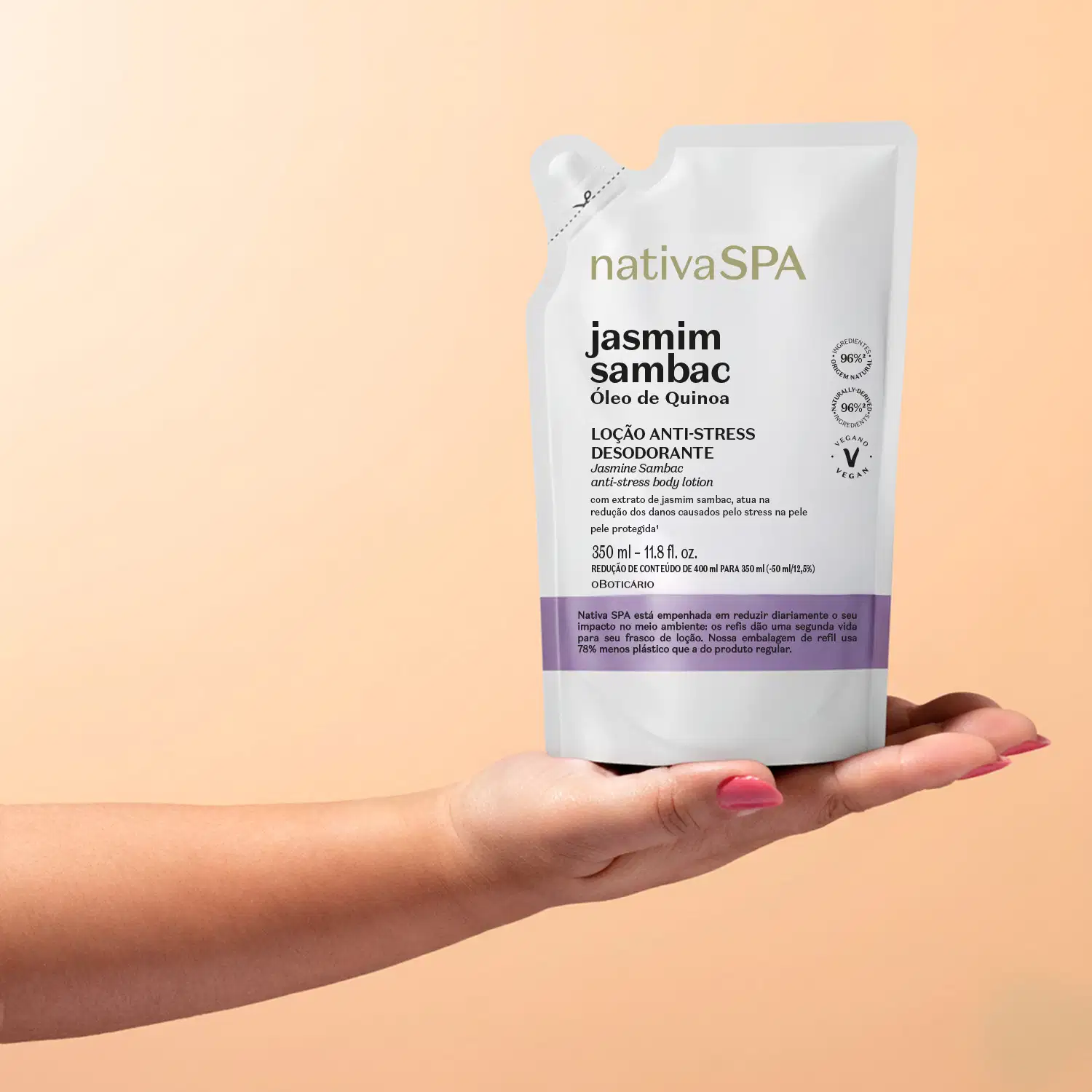 Imagem de embalagem refil branca e roxa da marca Nativa SPA Jasmim Sambac, sendo segurada por mão com unhas pintadas em fundo laranja claro.