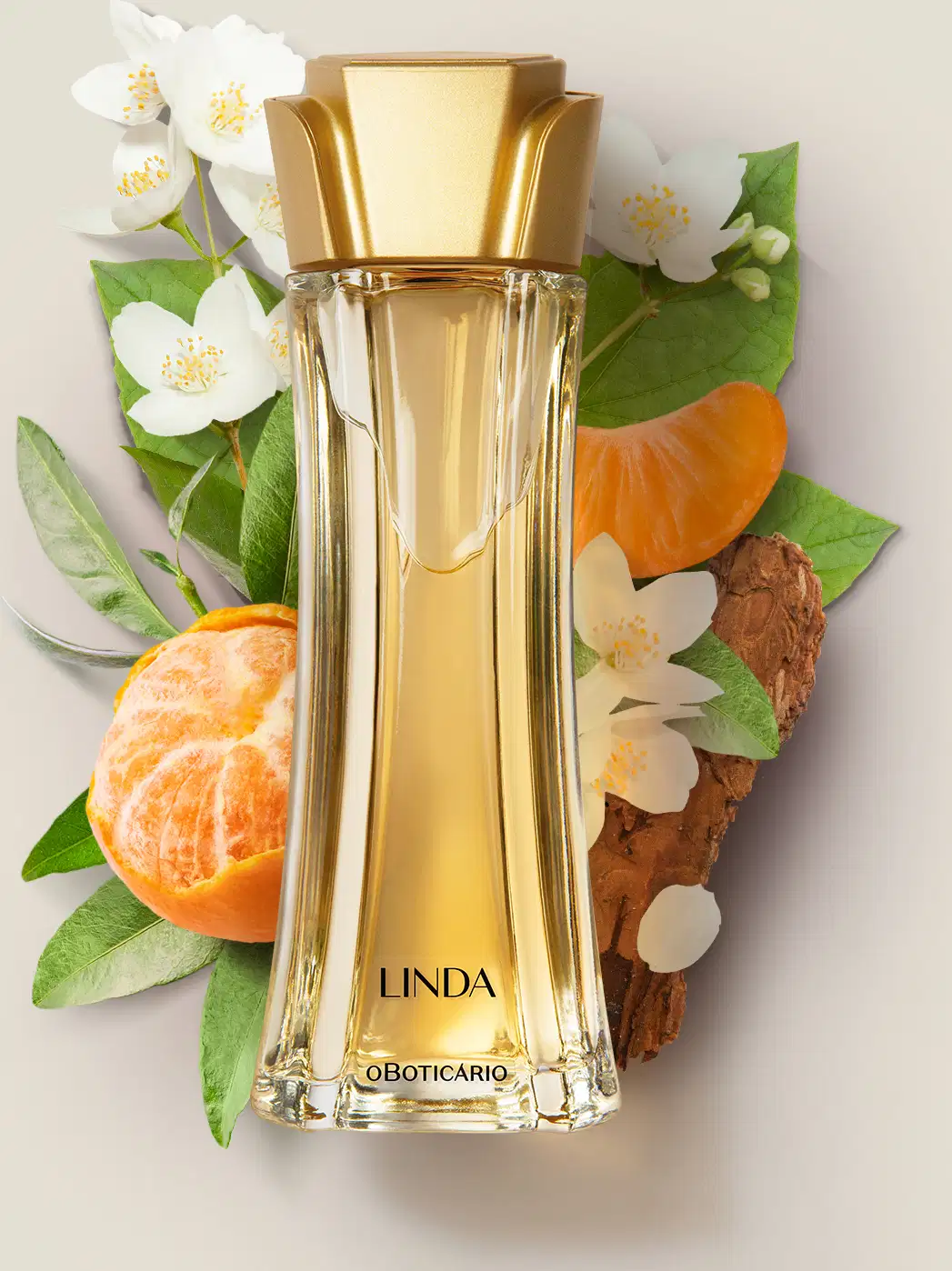 Vidro alongado com líquido bege e tampa dourada em forma de flor de desodorante colônia da marca Linda rodeado por bergamotas, flores brancas e folhas verdes.