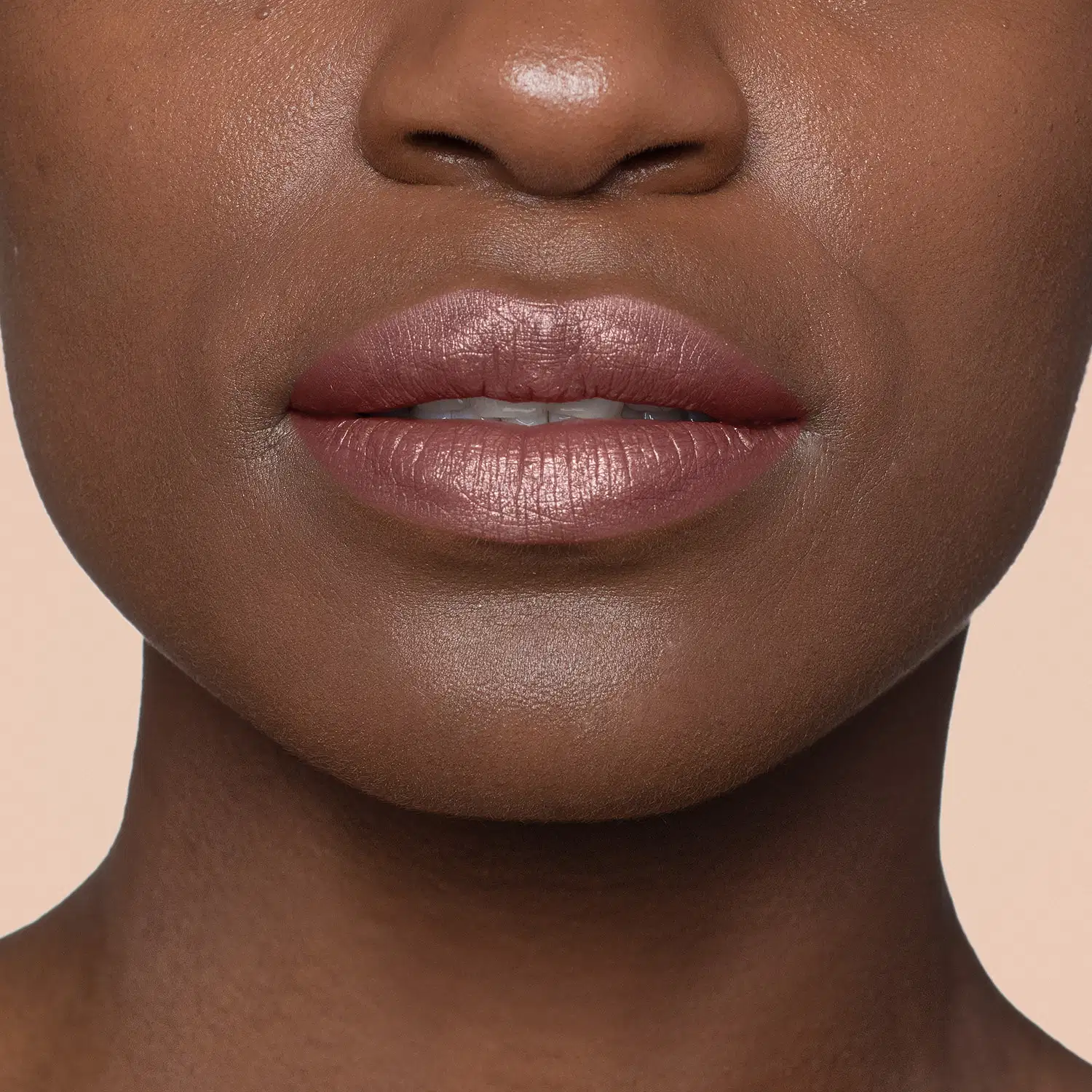 Close-up de um rosto feminino de pele negra evidenciando os lábios que usam o batom hidratante da marca Quem Disse, Berenice?.