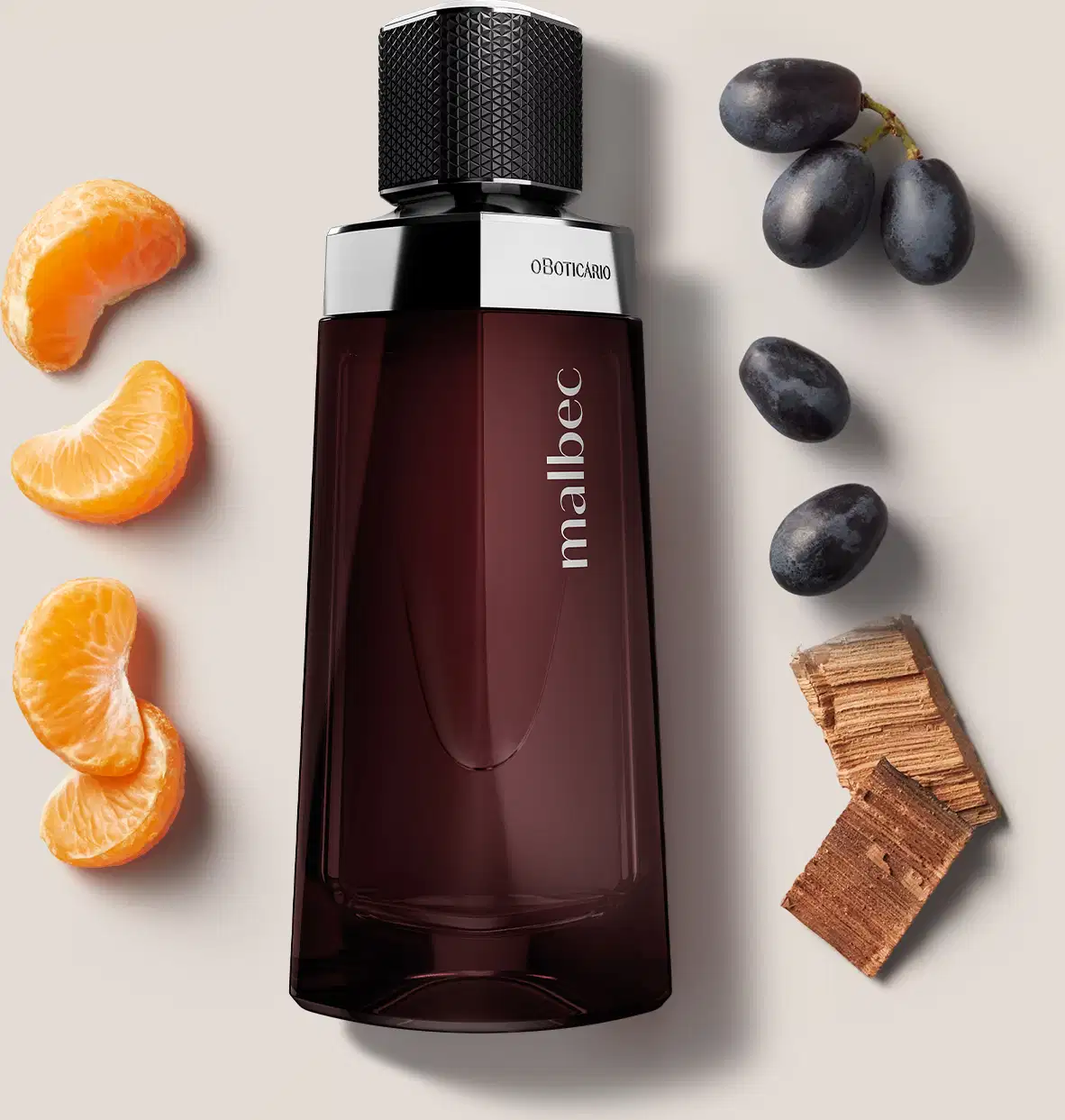 Frasco de vidro marrom com design geométrico com tampa preta texturizada de desodorante colônia Malbec com elementos decorativos espalhados ao redor, como gomos de tangerina e uvas pretas, sugerindo notas olfativas relacionadas a esses ingredientes.
