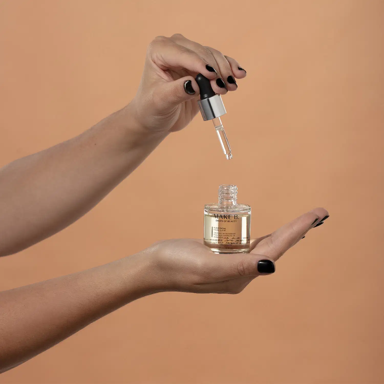 Uma mão feminina segura o frasco transparente com líquido claro e a outra mão segura o aplicador em conta-gotas em fundo bege.