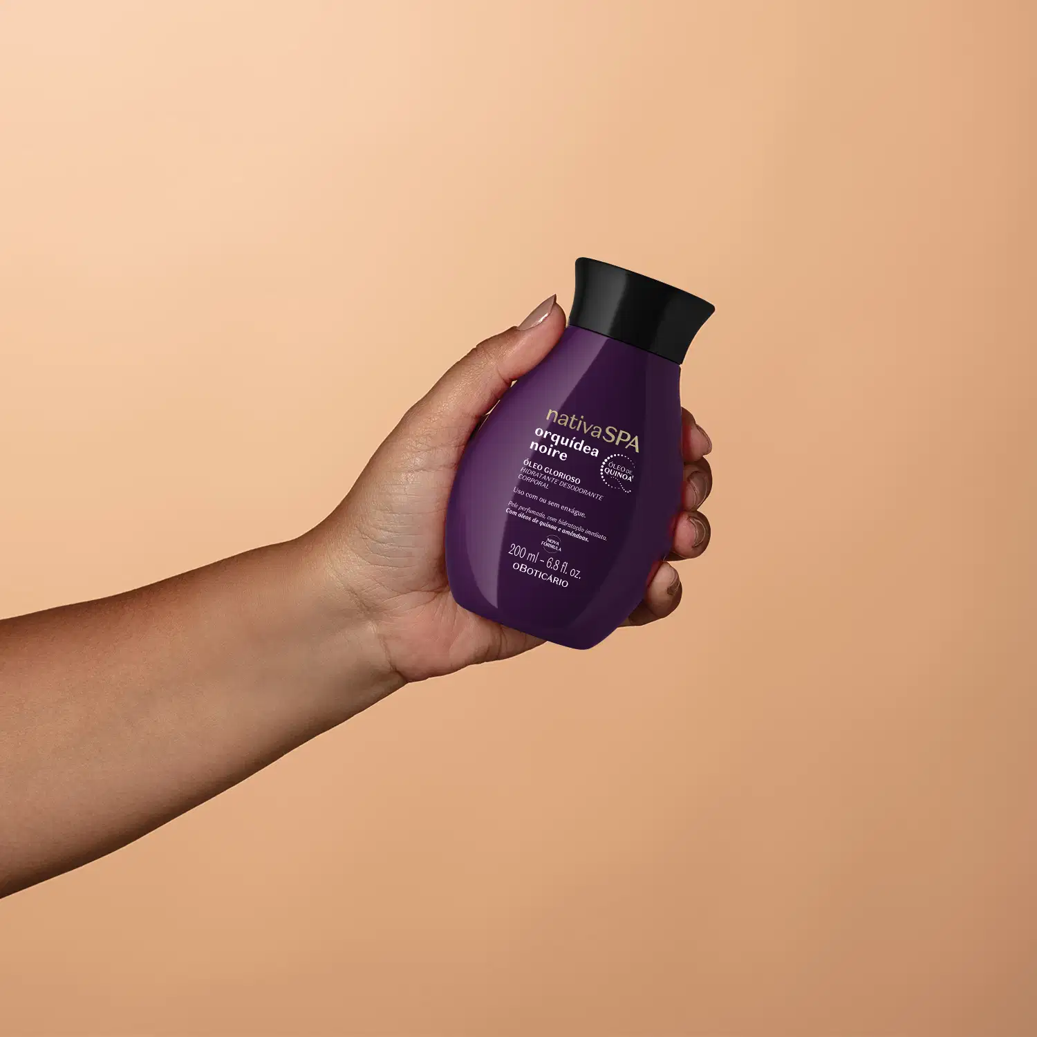 Imagem de um frasco de óleo glorioso corporal da marca Nativa SPA Orquídea Noire, em tom roxo, sendo segurado por uma mão em fundo roxo-claro.
