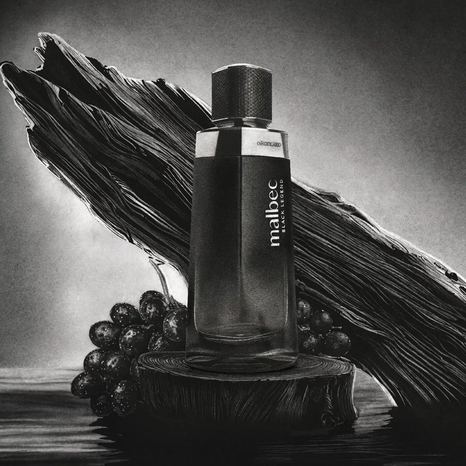 Imagem de um frasco de desodorante colônia Malbec Black Legend  preto com rótulo em letras brancas em fundo cinza vibrante com uvas pretas e arte escura atrás da embalagem.