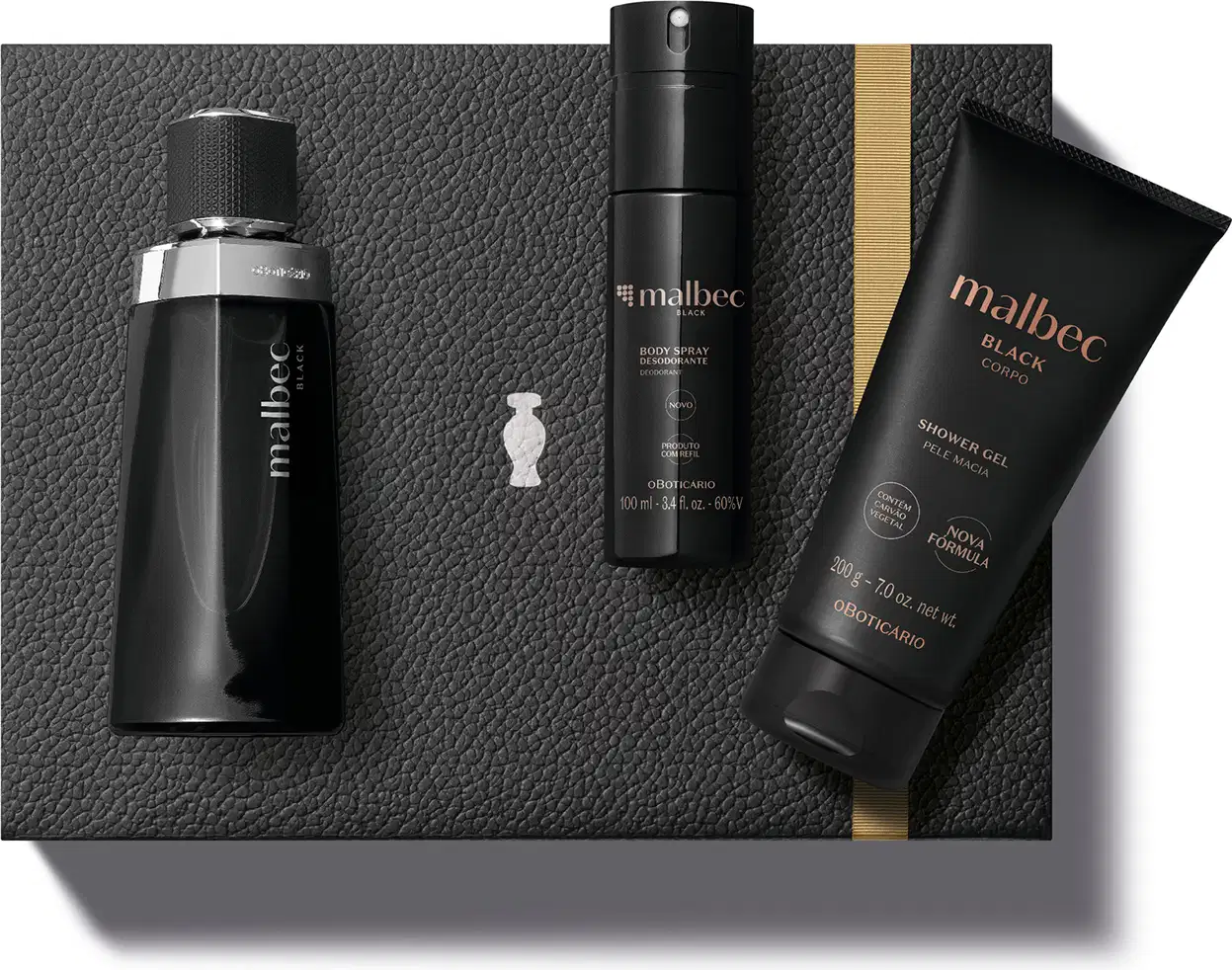 Caixa preta com fita dourada e detalhe prateado e três produtos Malbec: frasco preto com detalhes e letras prateadas de desodorante colônia, bisnaga preta com letras douradas de shower gel e embalagem preta com letras douradas de body spray.