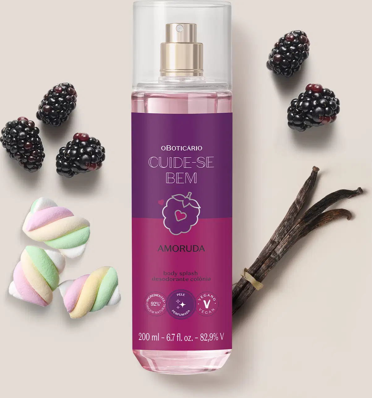Ambiente de beleza com body splash da marca Cuide-se Bem Amoruda, embalagem roxa com ilustração de amora, rodeado por amoras, marshmallows coloridos e um pedaço de baunilha, sugerindo uma fragrância doce e natural.