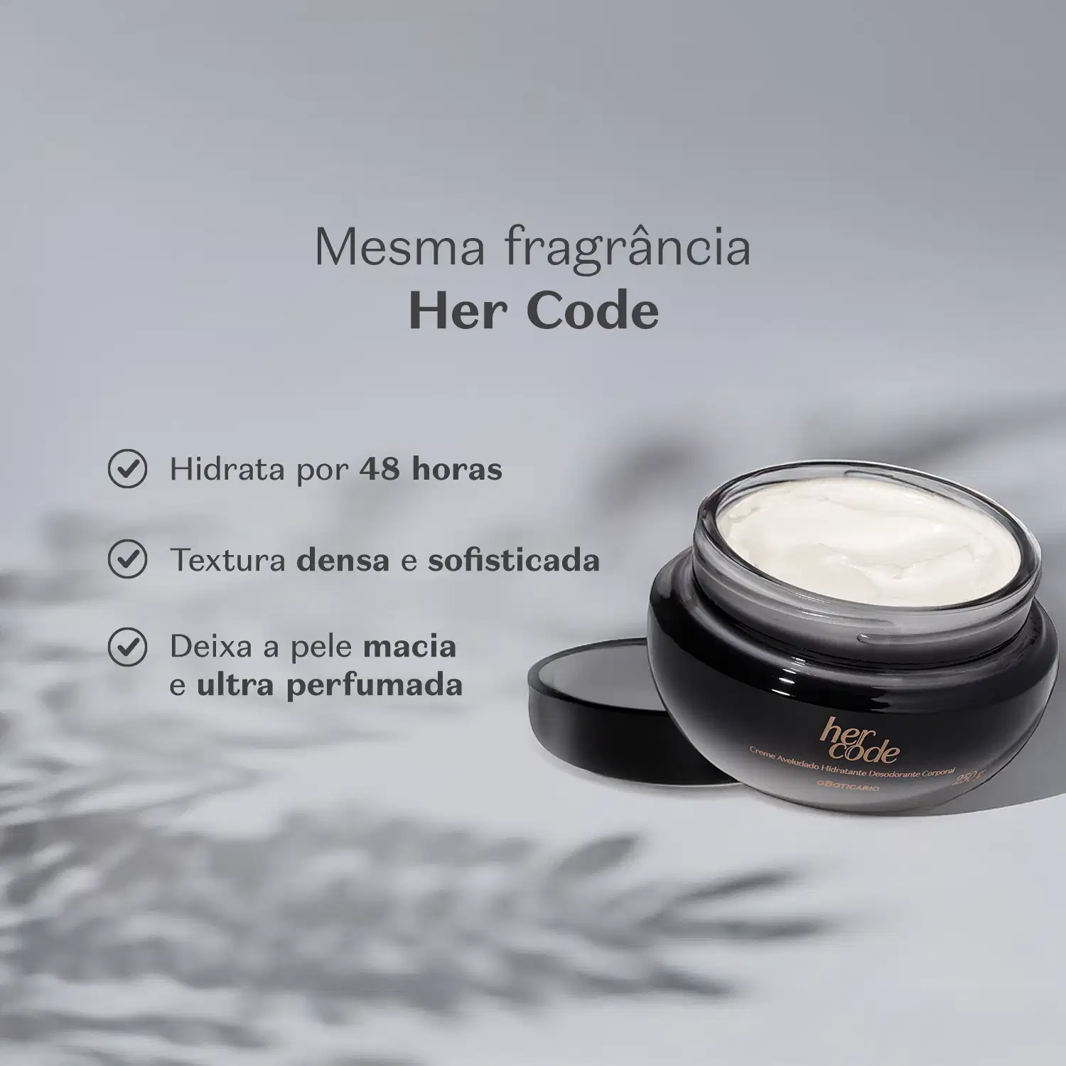 Recipiente preto e branco de creme hidratante corporal da marca Her Code sobre superfície clara com folhas desfocadas ao fundo, indicando um ambiente tranquilo e aconchegante.