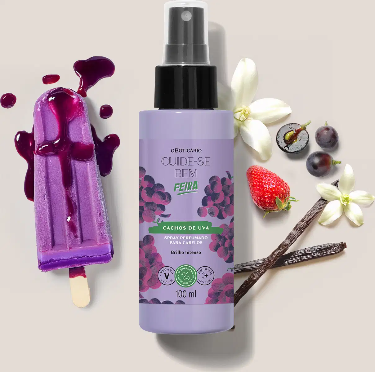 Embalagem de spray perfumado para cabelos Cuide-se Bem Feira Cachos de Uva em meio a flores, frutas e respingos de produto roxo sobre superfície clara.