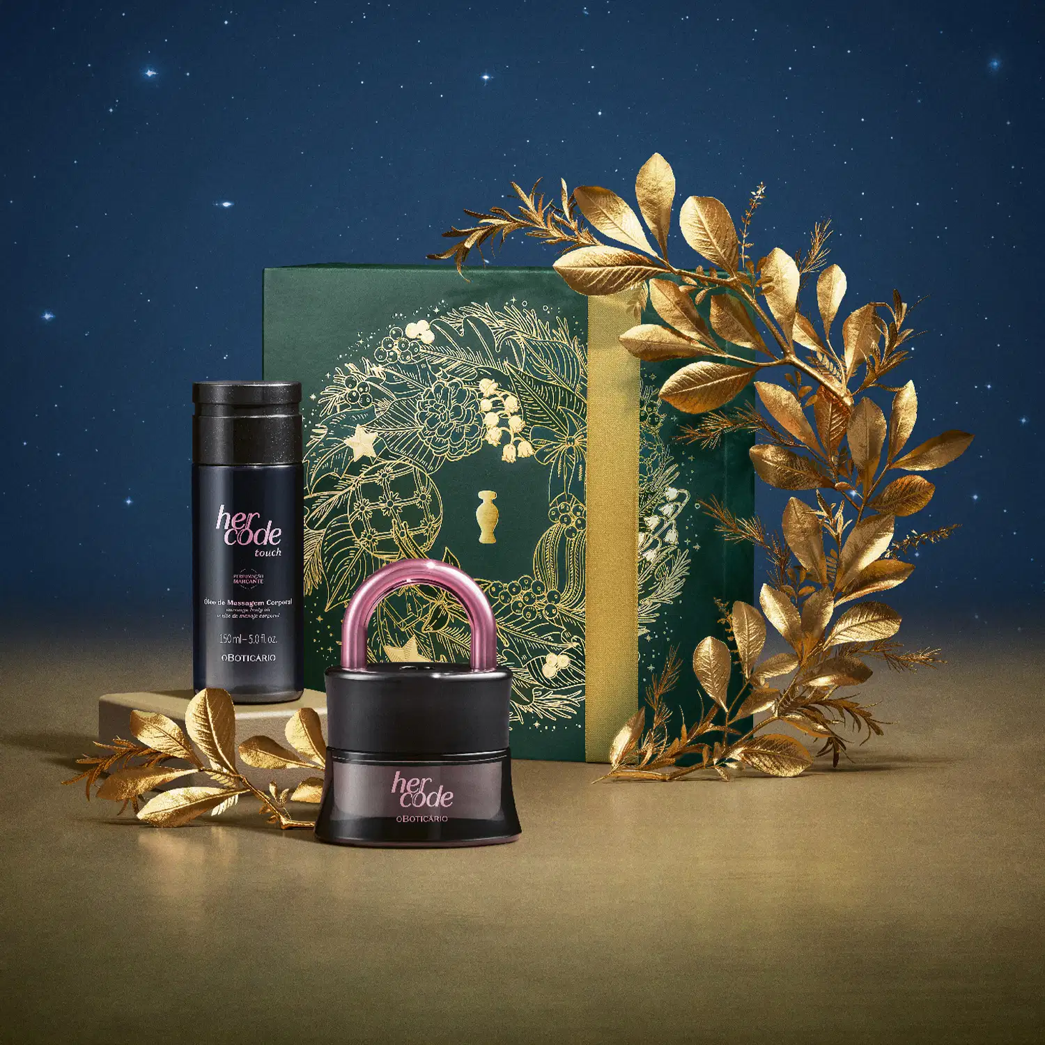 Imagem do Kit Presente Natal Her Code Touch com um vidro de desodorante colônia, um frasco de óleo de massagem corporal e uma caixa verde presenteável com estampa natalina em cenário com flores douradas, superfície marrom e fundo azul.