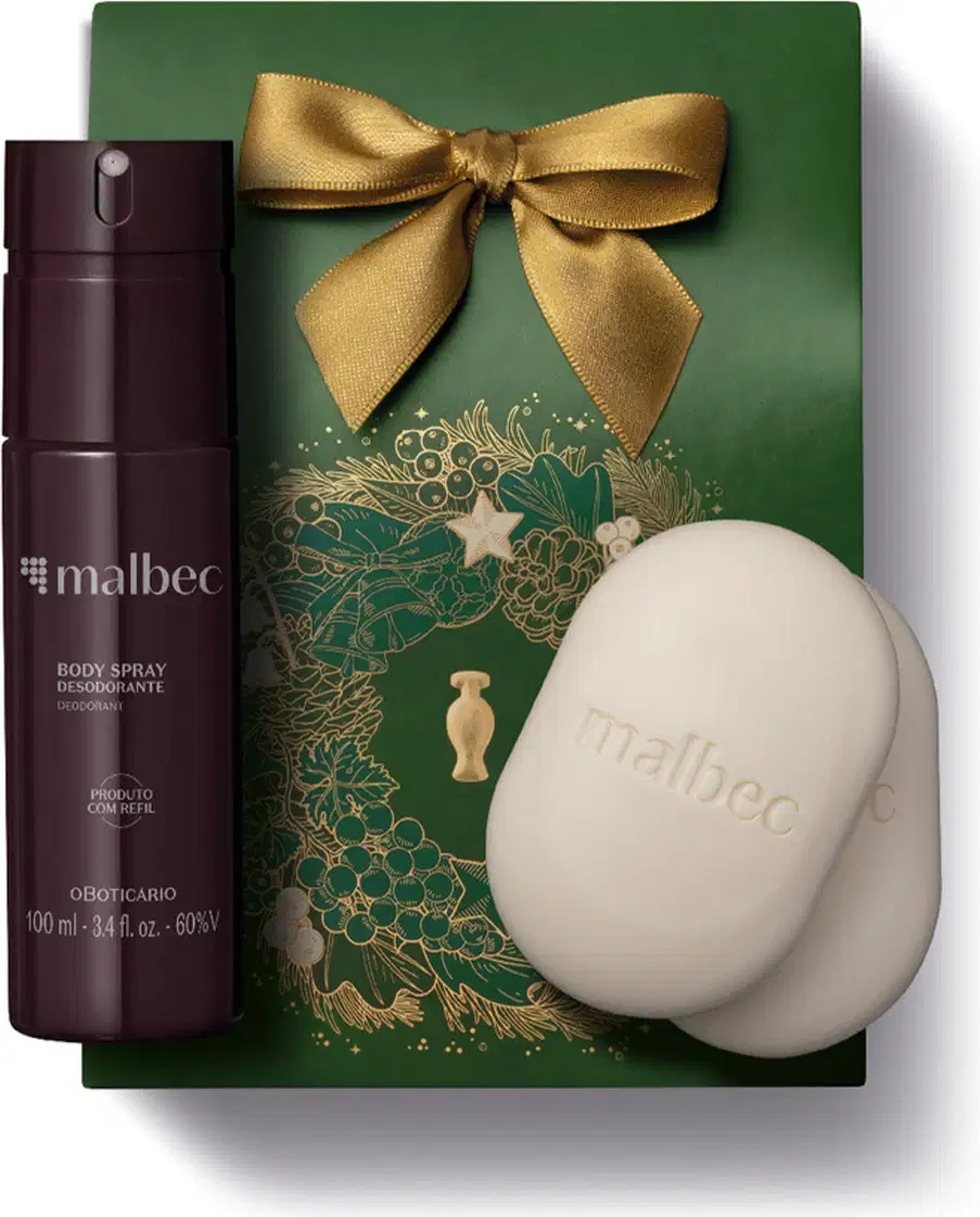 Imagem do Kit Presente Natal Malbec Cuidados com frasco vinho e cinza de body spray e dois sabonetes em barra brancos sobre uma sacola presenteável verde com estampa natalina.