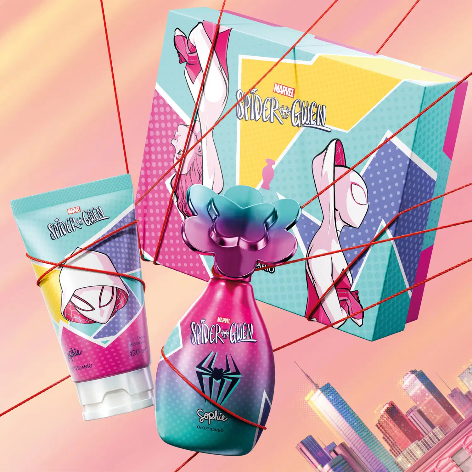 Frasco de colônia infantil, bisnaga de creme corporal e caixa presenteável da marca Sophie Marvel Spider-Gwen em tons de rosa, azul, violeta e amarelo, com flores e elementos gráficos presos por linhas vermelhas sobre fundo rosa com o skyline urbano.