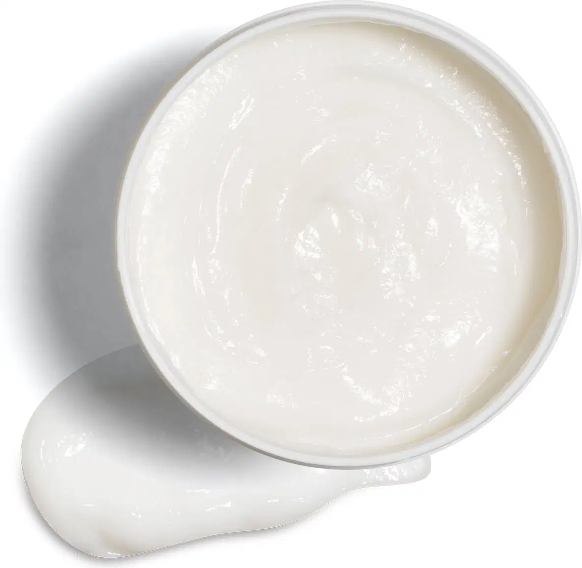 Imagem de um pote branco aberto contendo creme branco dentro e um pouco do mesmo produto no fundo da imagem.