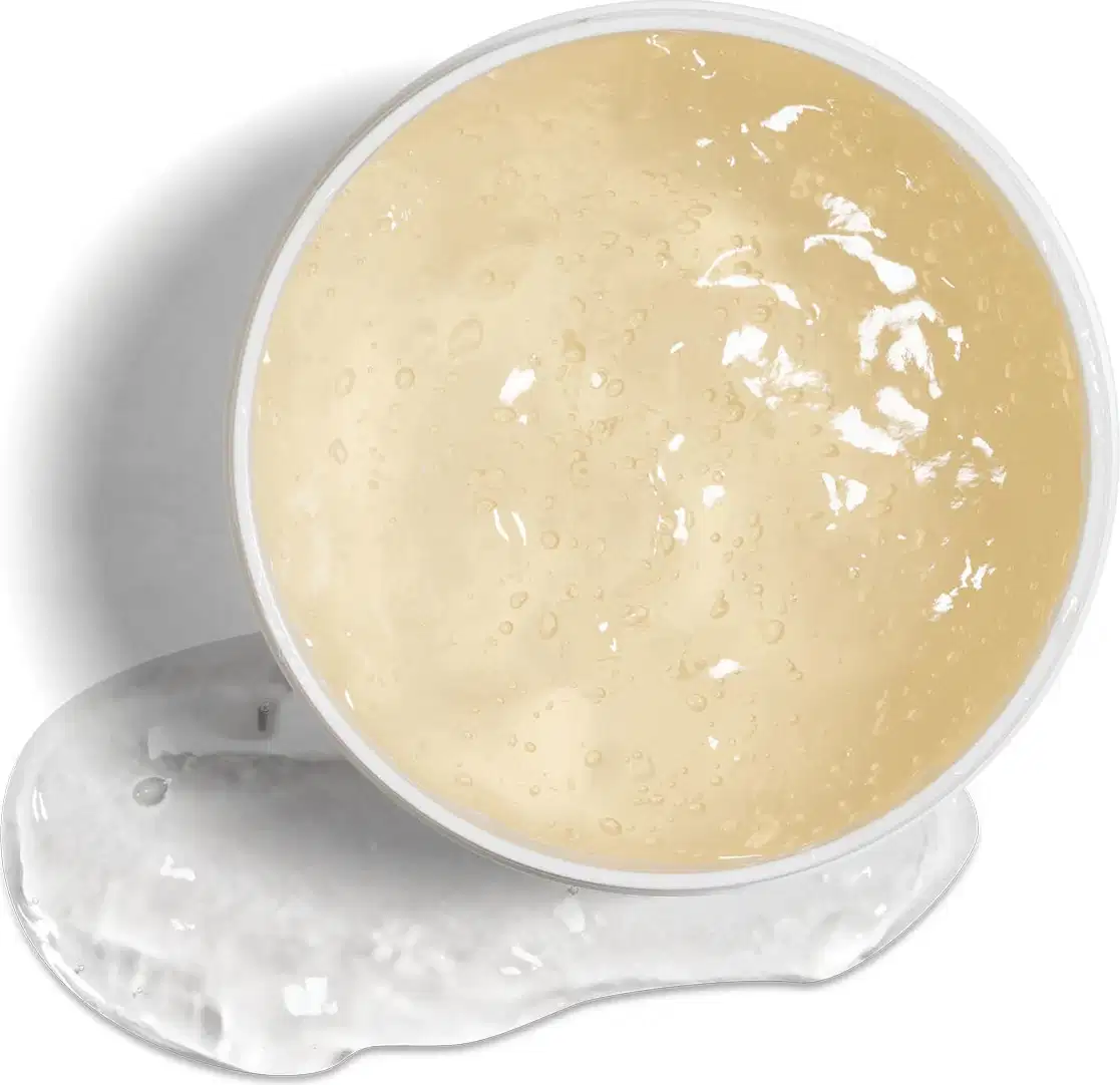 Imagem da textura gelatinosa e translúcida do jelly capilar. Ele possui tom amarelado, com pequenas bolhas e brilho, em recipiente de plástico sobre superfície clara.