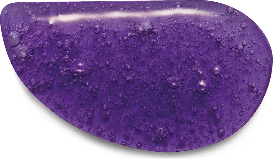 A imagem mostra a textura roxa brilhante e com bolhas do sabonete líquido, com aspecto úmido e gelatinoso, ocupando toda a superfície da imagem.