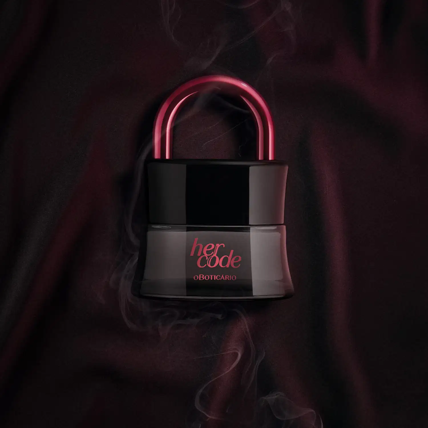 Imagem de um vidro preto em formato de cadeado com arco rosa metalizado de Eau de Parfum Her Code Clímax, suspensa em ambiente escuro com fumaça, sobre superfície escura.