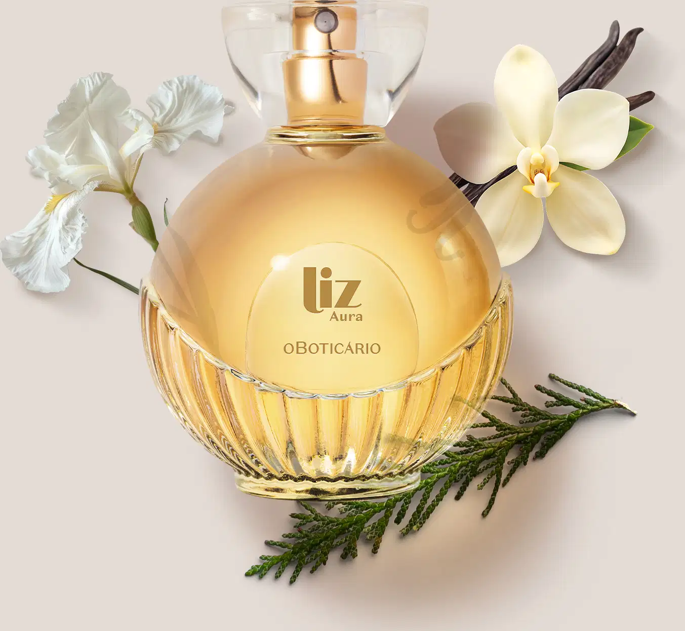 Frasco de desodorante colônia da marca Liz Aura em recipiente de vidro com líquido dourado, rodeado por flores brancas e folhagens verdes sobre fundo bege claro.