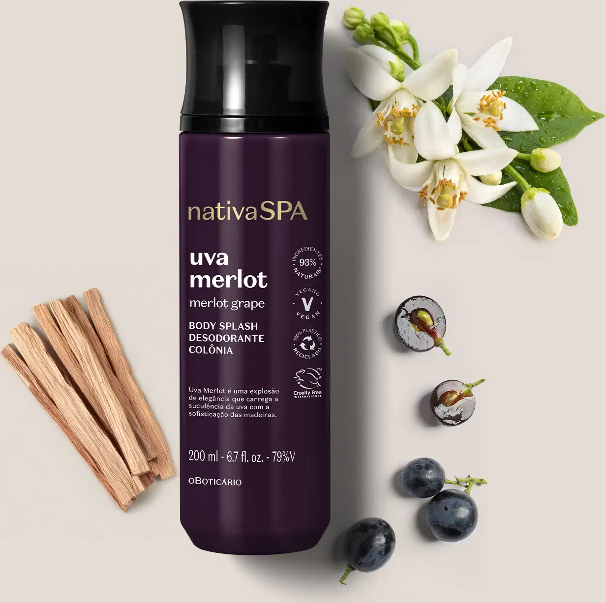 Ao lado do frasco roxo e preto de body splash Nativa SPA Uva Merlot há alguns ingredientes naturais relacionados à fragrância, como uvas e flores brancas. O fundo é lilás bem claro.