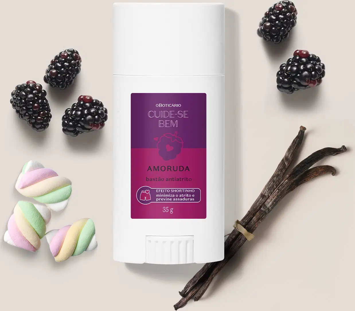 Embalagem branca de bastão anti-atrito da marca Cuide-se bem Amoruda, rodeada por amoras frescas, marshmallows coloridos e bastões de baunilha em superfície bege clara.